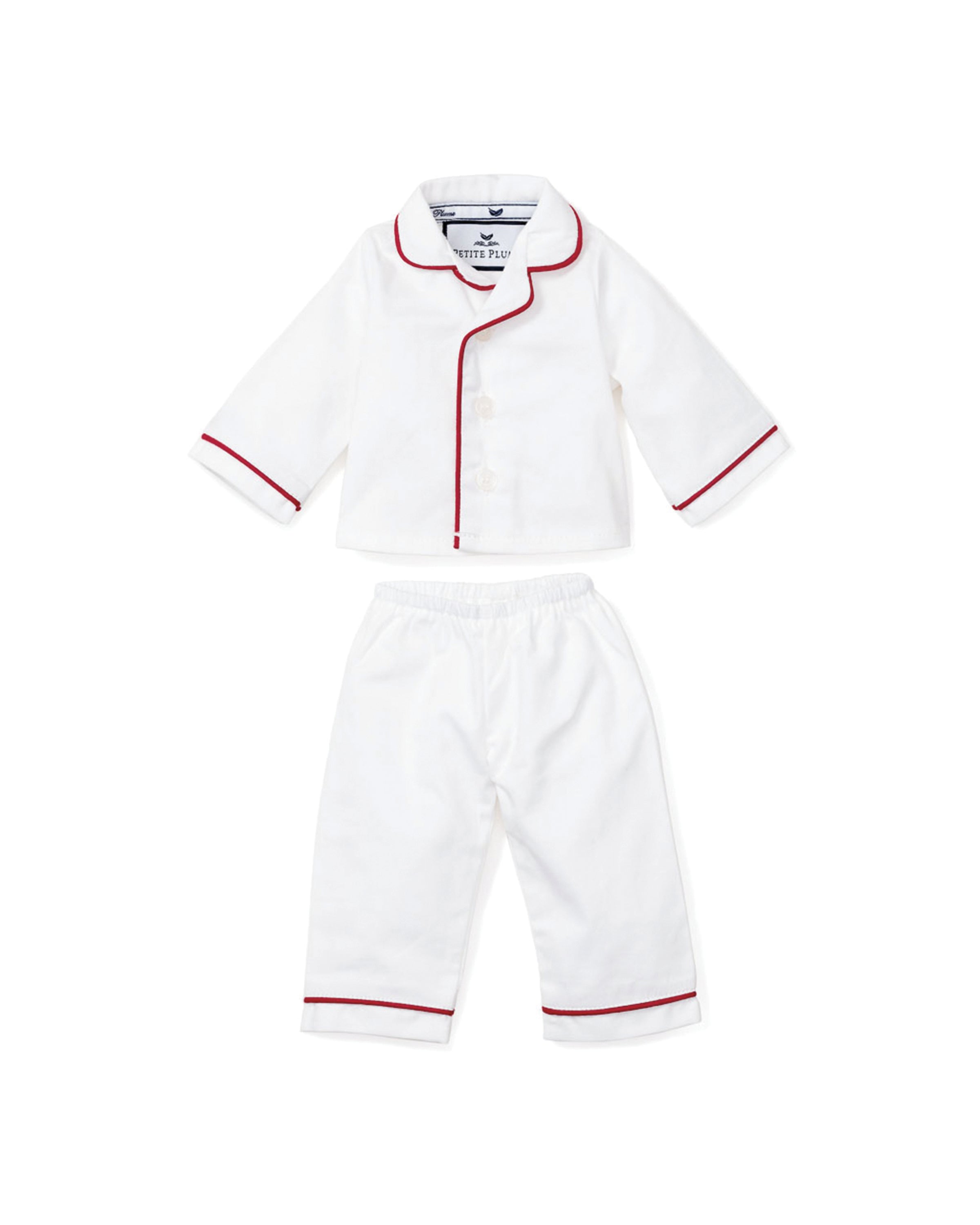 Petite Plumes White Doll Pajamas with Red Piping offer a charming childrens set, including a long-sleeve button-up shirt and matching pants adorned with red piping on the collar, cuffs, and hem. Perfectly styled to match their favorite 18 dolls cozy nighttime attire.