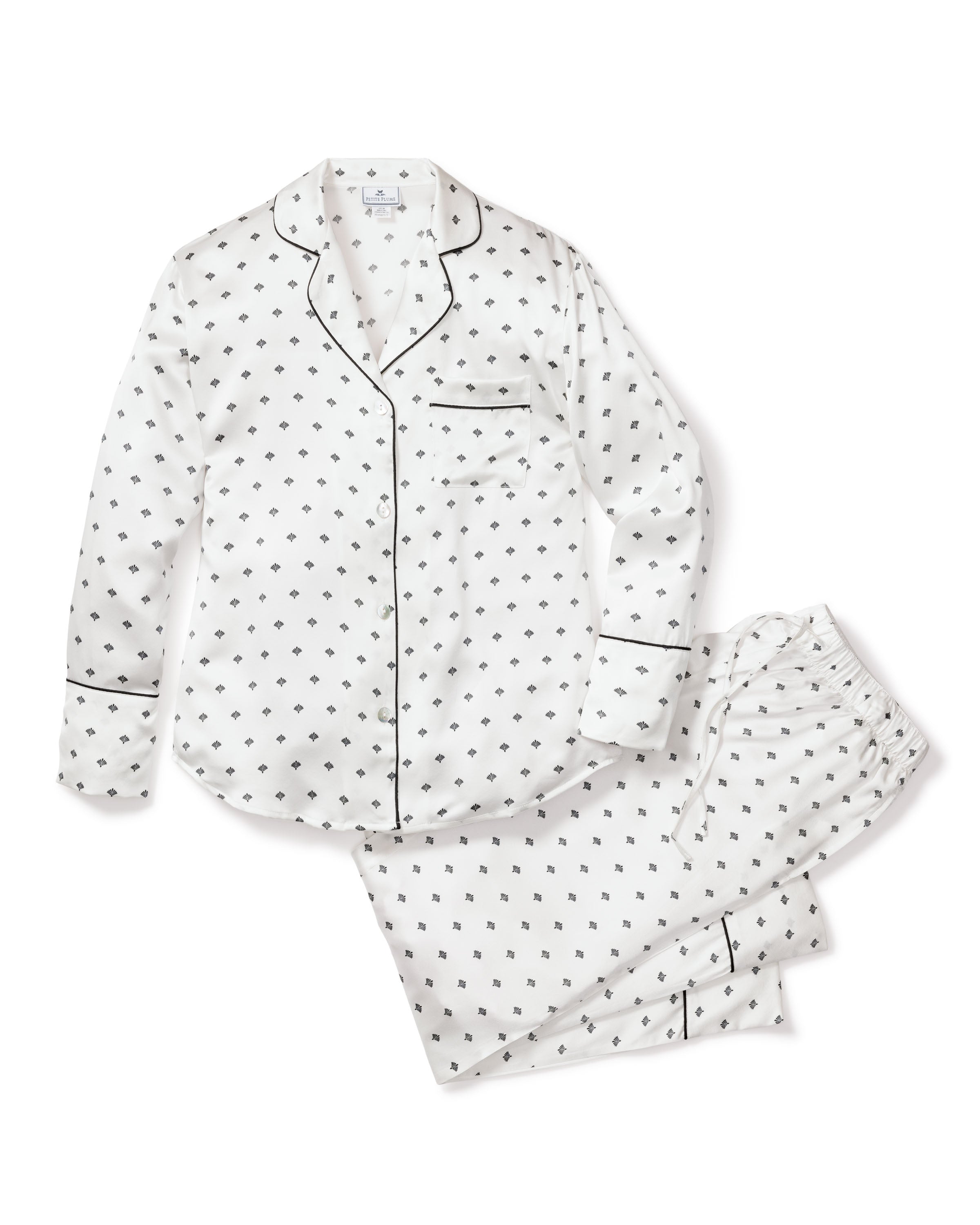 Indulge in luxury with Petite Plumes Womens Silk Pajama Set in White Art Nouveau, featuring a classic old Hollywood-inspired black diamond pattern. Includes a long-sleeve button-up shirt with a front pocket and black trim, paired with matching pants and an elastic waistband.