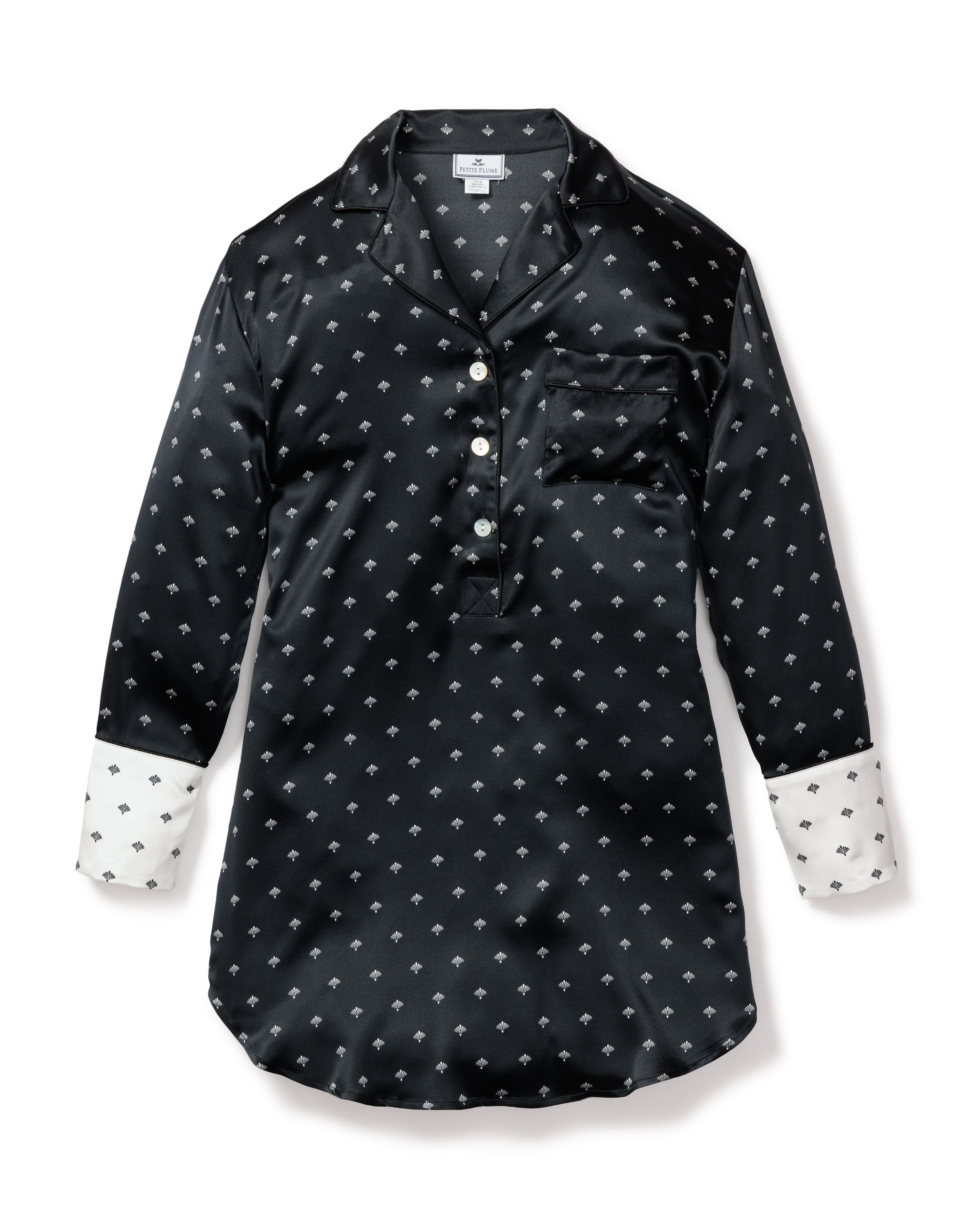 The Womens Silk Nightshirt in Black Art Nouveau by Petite Plume features long sleeves, a white collar and cuffs, subtle white art deco fan patterns, a button-up front, and a left chest pocket for a touch of Truman Capote-style sophistication.