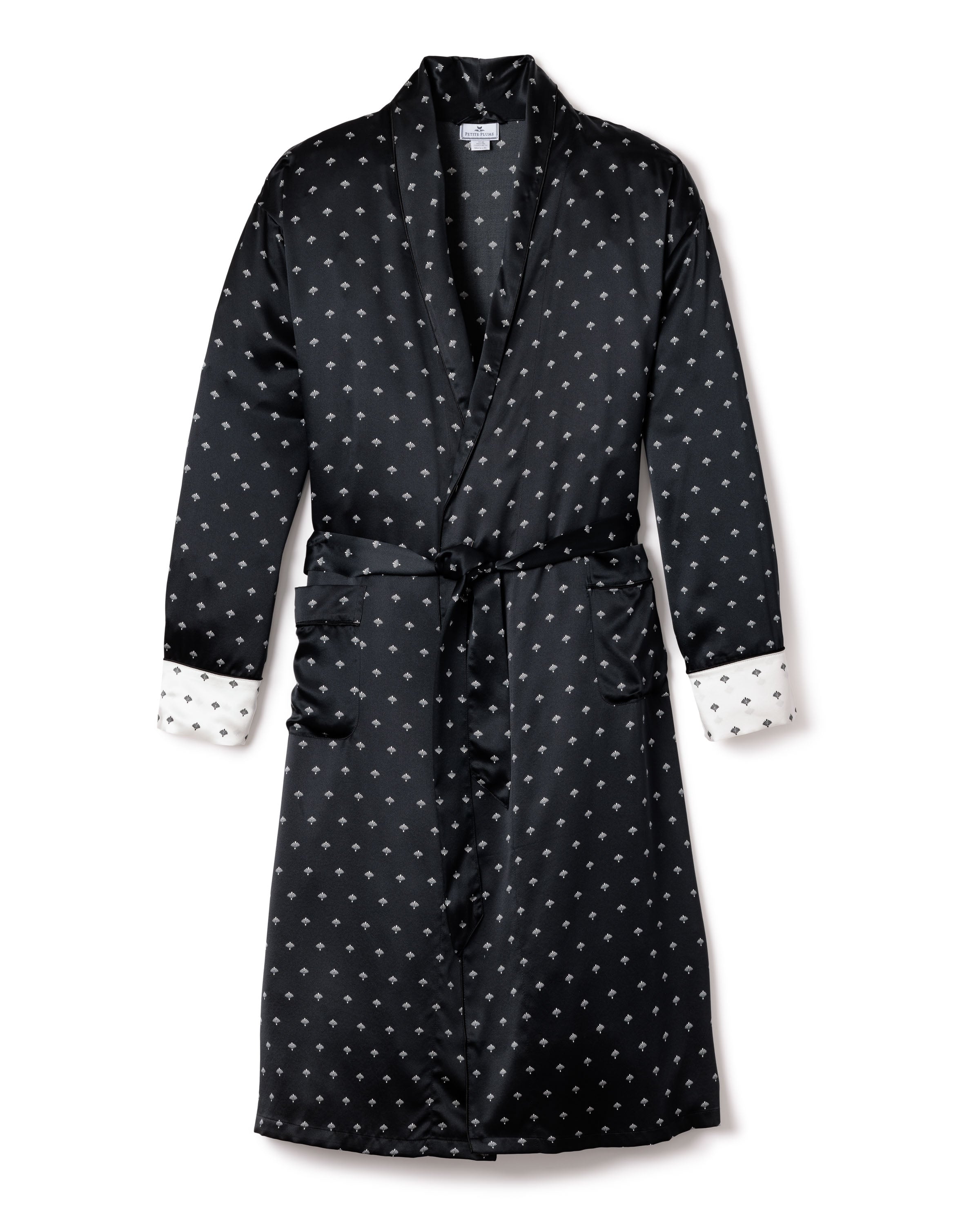 The Mens Silk Long Robe in Black Art Nouveau by Petite Plume is ideal for sleepwear, featuring a charming pattern of small white stars. It drapes elegantly with a matching waist tie, while white cuffs adorned with black star patterns add whimsy to its sophisticated design.