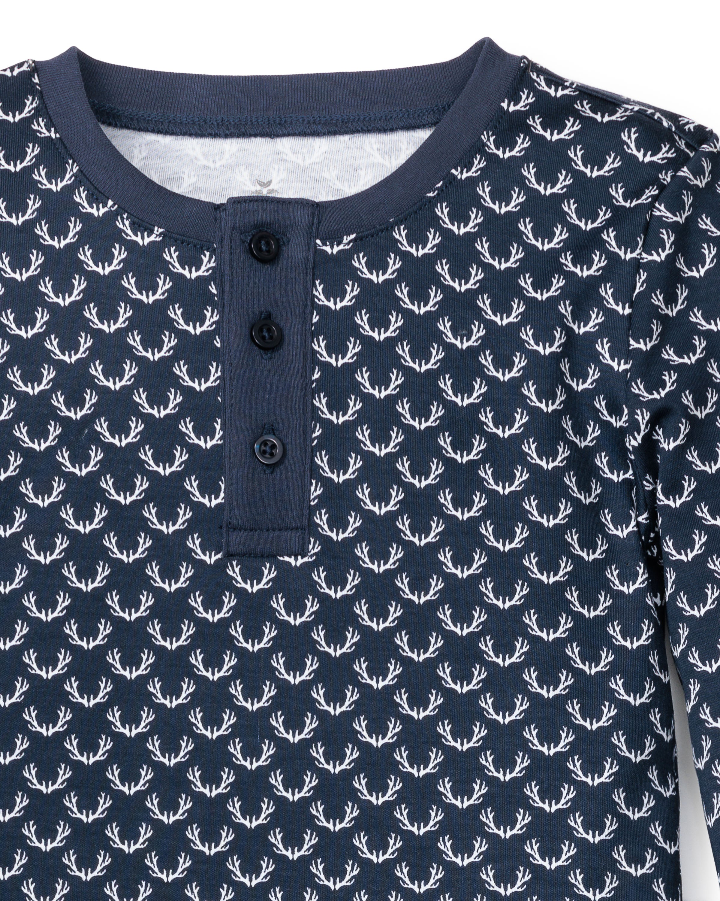 The Kids Pima Snug Fit Pajama Set Nordic Antlers by Petite Plume features a blue long-sleeve shirt made from soft Pima cotton with a white deer antler pattern and navy buttoned placket, ideal for elegant sleepwear or paired with matching pants for a complete set.