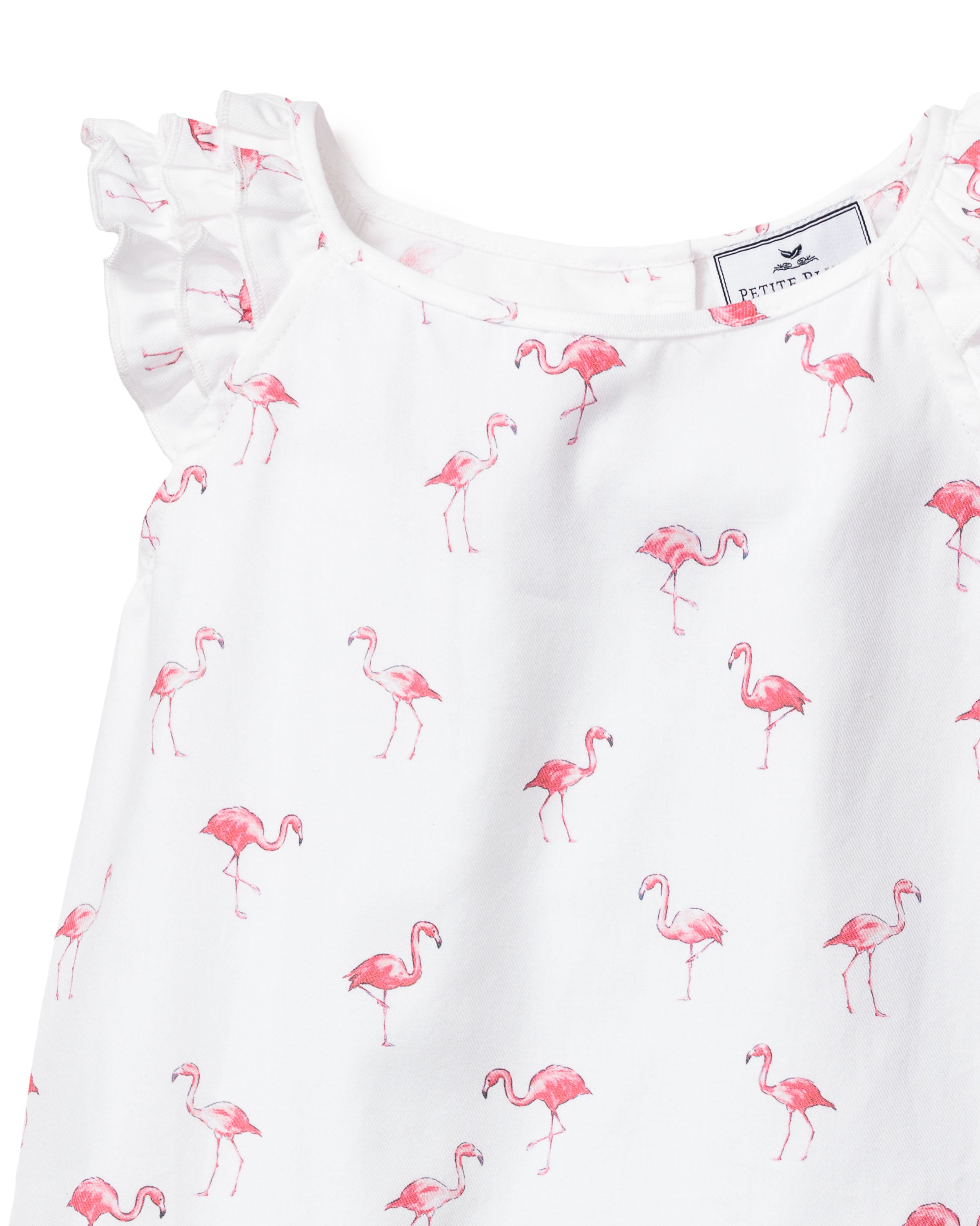 The Girls Twill Amelie Short Set by Petite Plume features a white sleeveless pajama dress with ruffled shoulders and charming small pink flamingos, offering a whimsical touch of comfort.