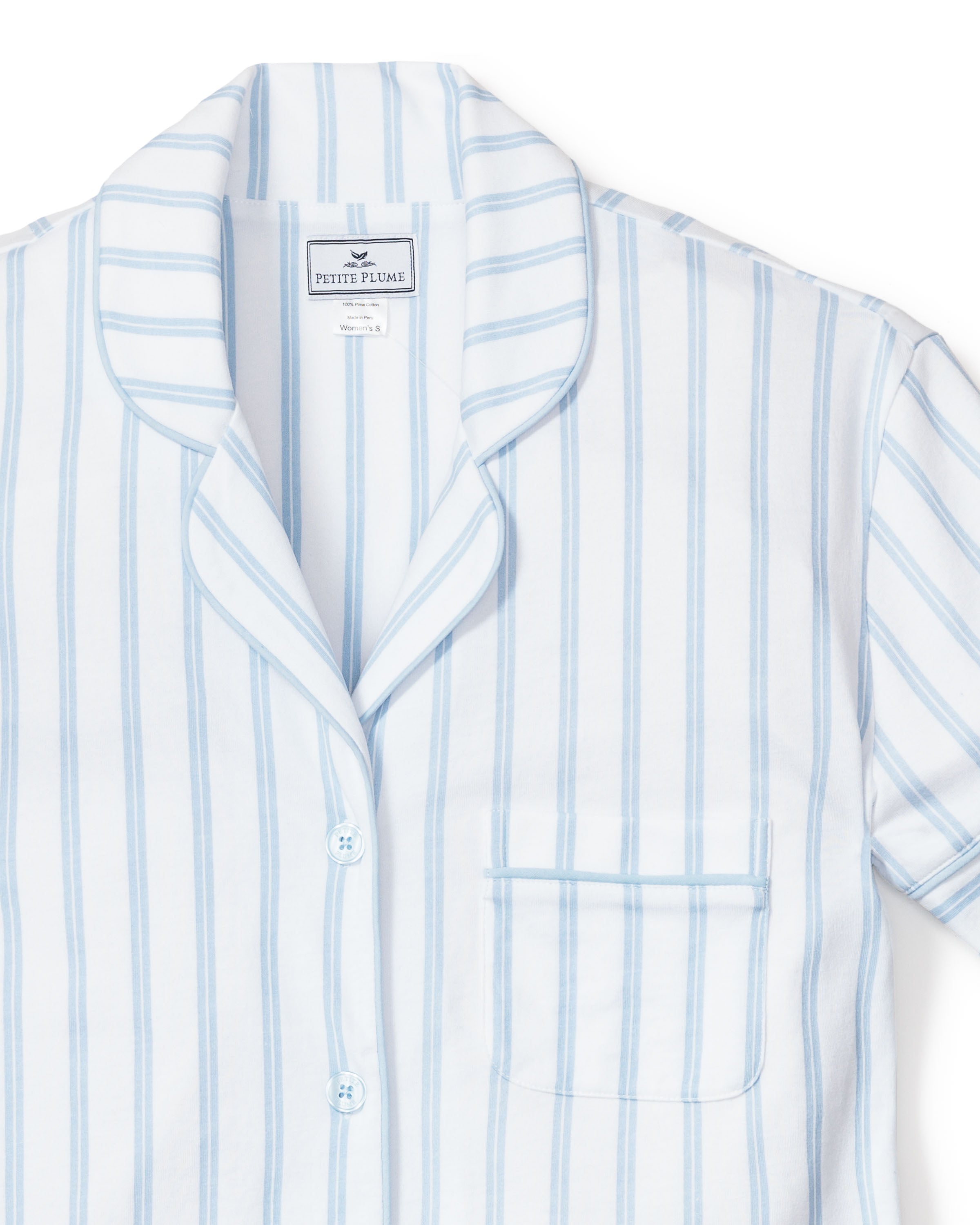 The Womens Pima Pajama Short Set in Periwinkle and White Stripe by Petite Plume features a soft short-sleeve button-up top with a chest pocket, notched collar, and signature label—ideal for those seeking luxury sleepwear.