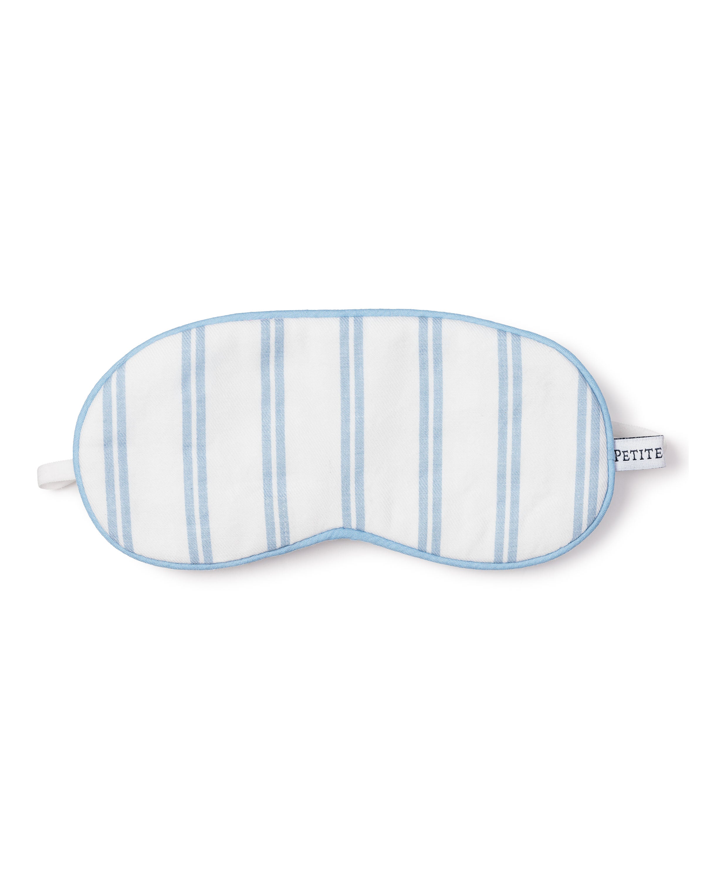 The Kids Sleep Mask in Periwinkle Stripe by Petite Plume sports a white and light blue striped design with a light blue trim and side tag, blending style and comfort for a luxurious dreamland experience.