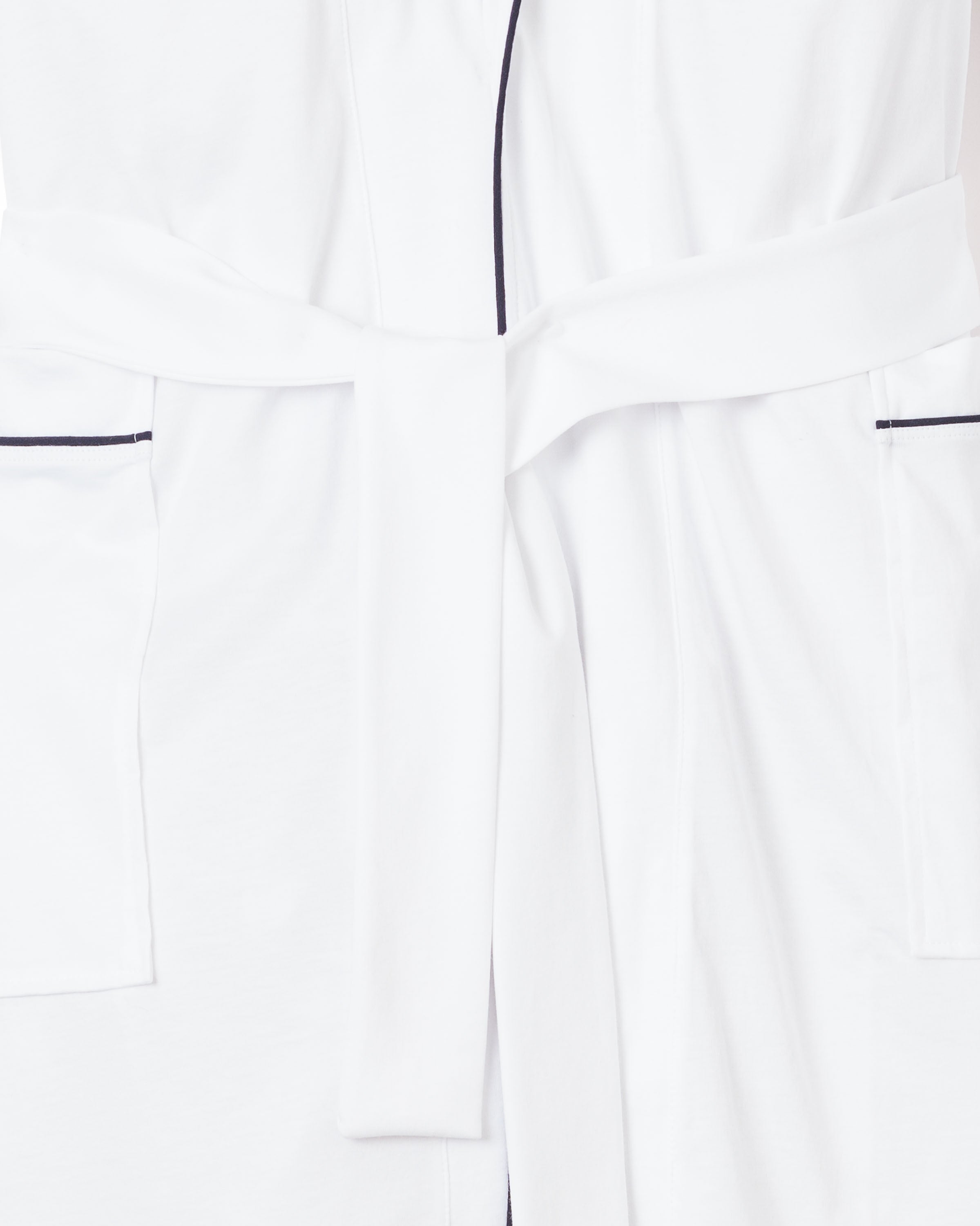 Close-up of the Mens Pima Robe in White with Navy Piping by Petite Plume, showcasing a tied waist belt and dark piping. Made from opulent Peruvian Pima cotton, this robe features double pockets and soft, smooth fabric.