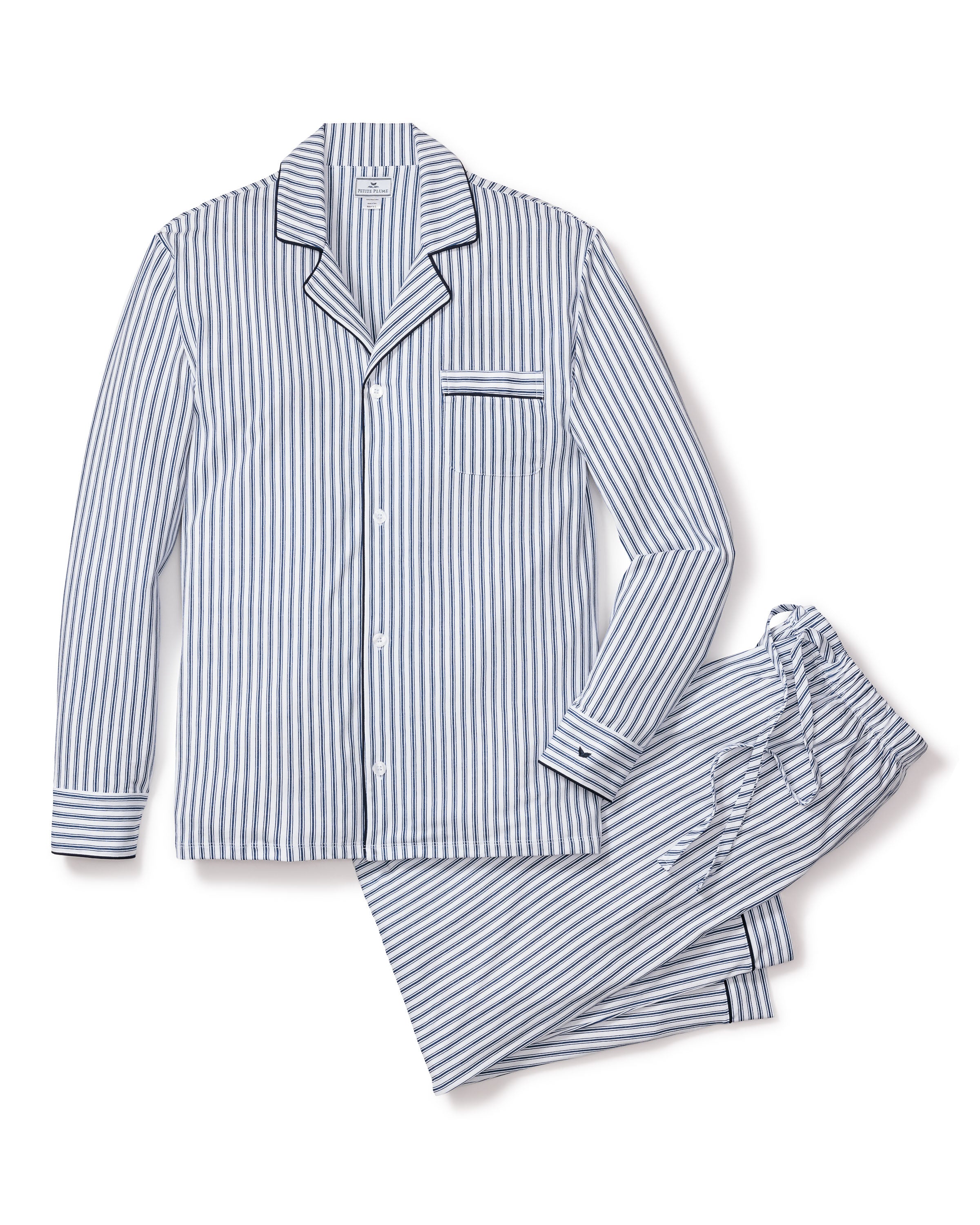 Petite Plumes Mens Pima Pajama Set in Navy French Ticking offers a luxurious look with blue and white vertical stripes, a long-sleeved button-up shirt featuring a chest pocket, and matching pants. Both the shirt cuffs and pant hems have horizontal stripe accents for extra style.