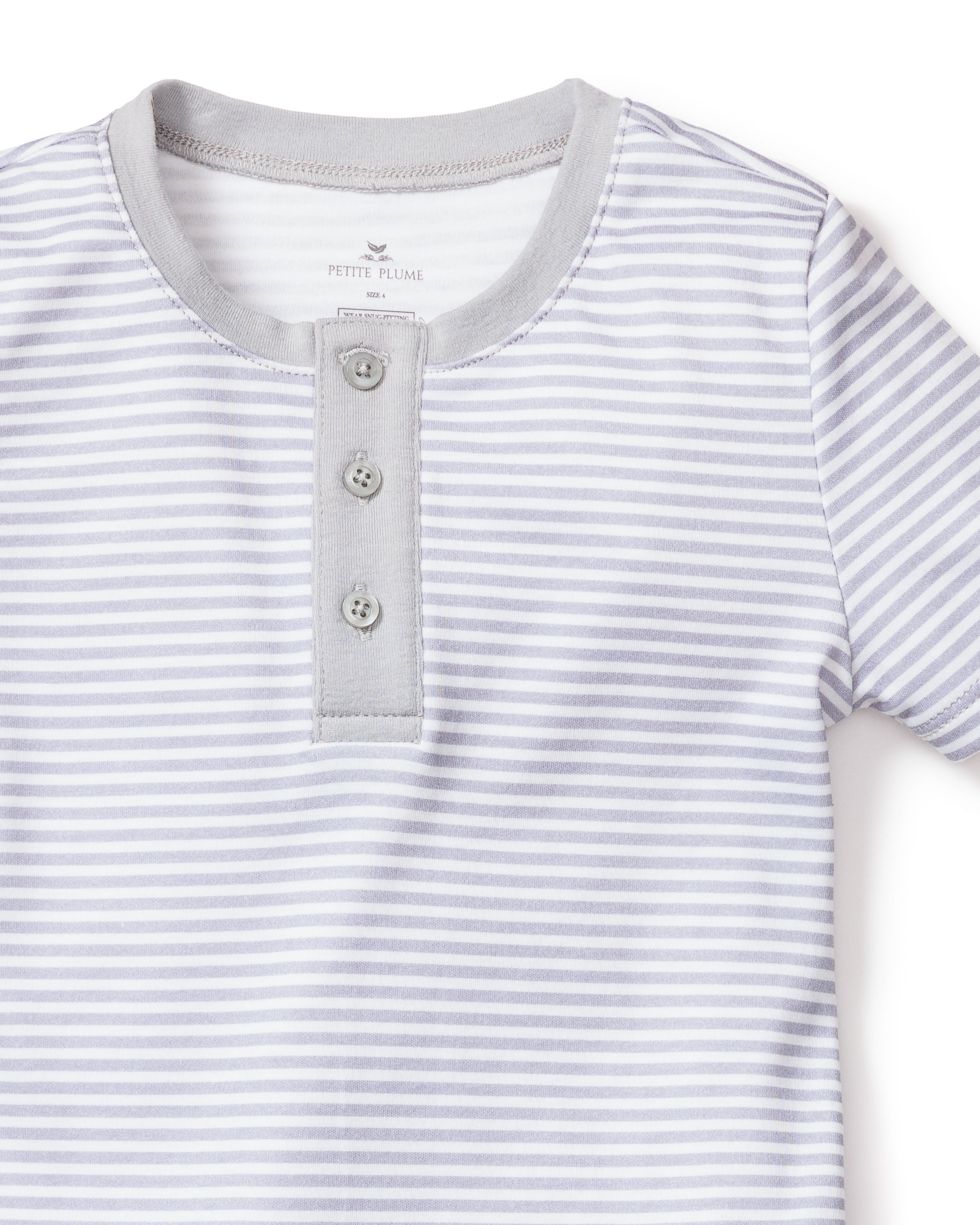 The Kids Pima Snug Fit Pajama Short Set in Grey Stripes by Petite Plume features a soft Pima cotton short sleeve top with light gray and white stripes, a rounded neckline, and a three-button gray placket for an elegant touch, ideal for cozy sleepwear or casual outings.