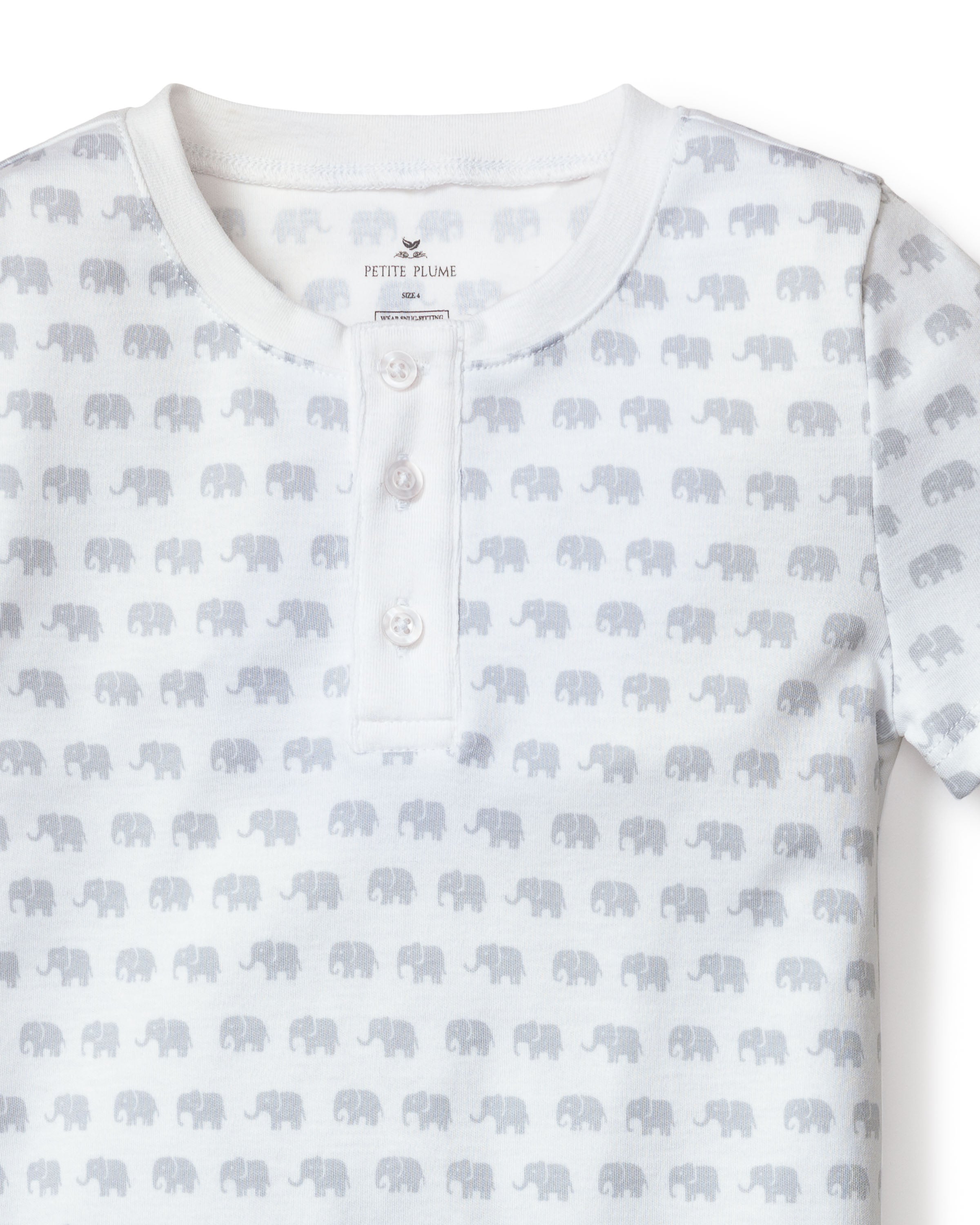 Close-up of Kids Pima Snug Fit Pajama Short Set in Grey Elephants by Petite Plume, a white shirt with subtle grey elephants print. Crafted from 100% Pima Cotton, it features a round neckline and three-button placket.