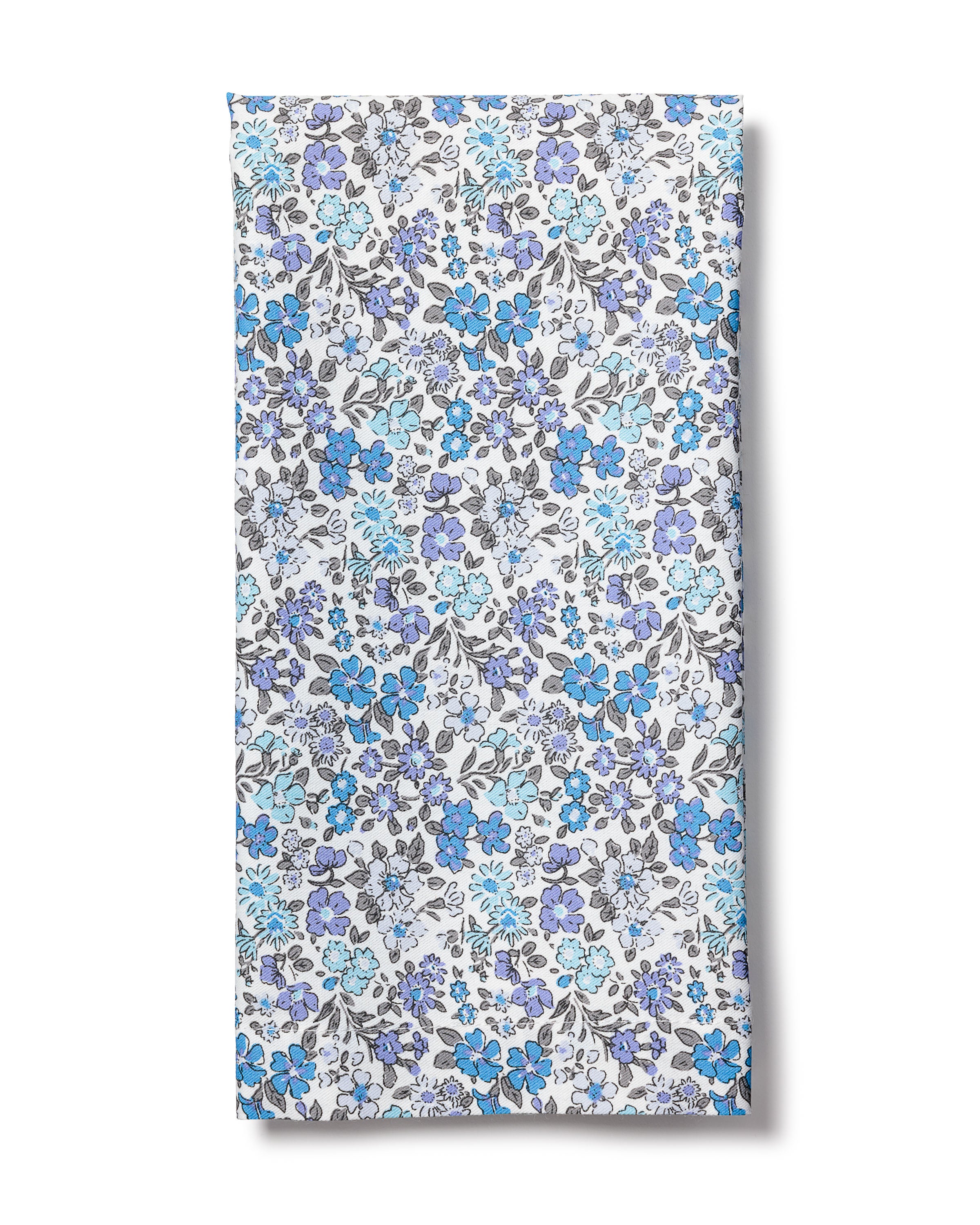 The Signature Twill Napkins in Fleur DAzur by Petite Plume are made from 100% cotton, featuring a floral pattern with blue, purple, and grey flowers on a white background. The design is dense and symmetrical, ideal for creating elegant table linens.
