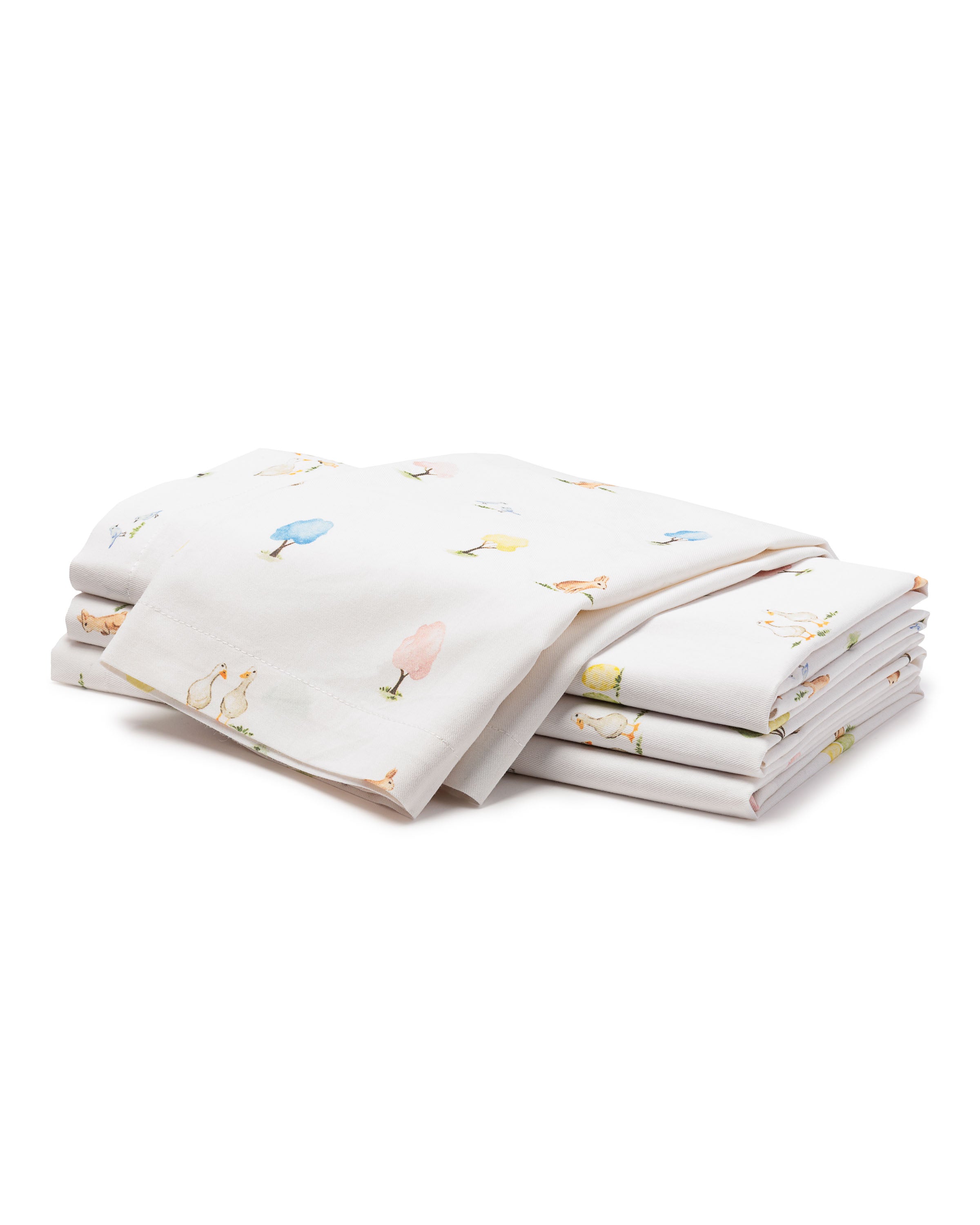 The Easter Gardens Table Linen set by Petite Plume boasts colorful, minimalist tree and bird designs on 100% cotton, arranged against a plain white background. The neatly folded stack evokes vibrant simplicity reminiscent of artful bed sheets.
