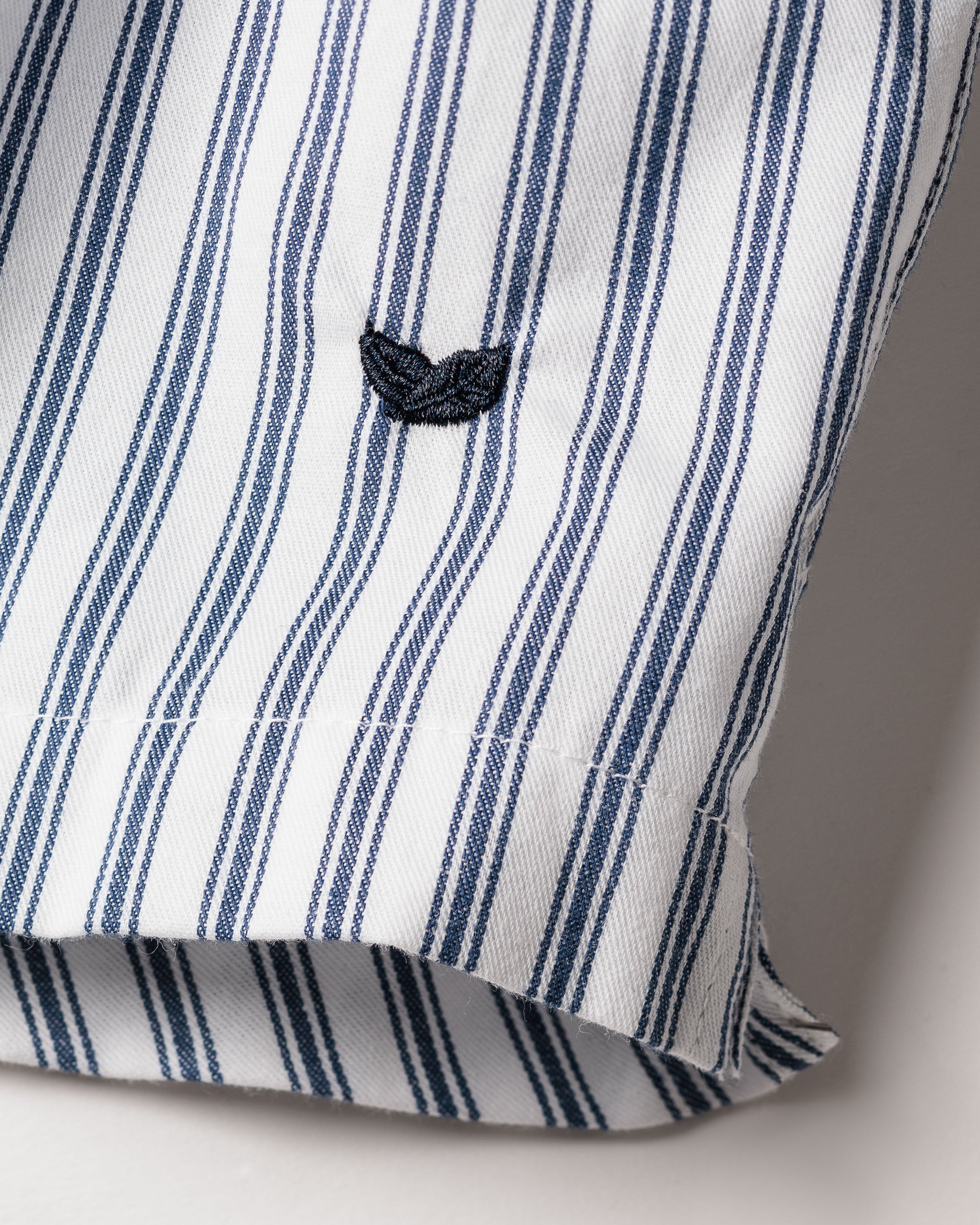 A close-up of the Petite Plume Mens Twill 3 Pack Boxers in Navy showcases the textured woven cotton twill fabric with vertical blue stripes and small black leaf motifs, reminiscent of classic fit boxers. The hem is visible at the bottom.