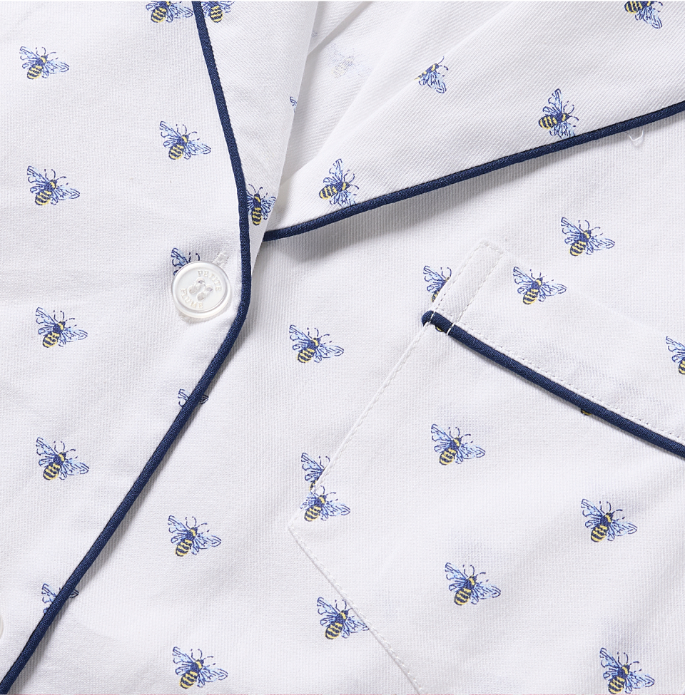 Close up of white and navy pajama top with Bee design