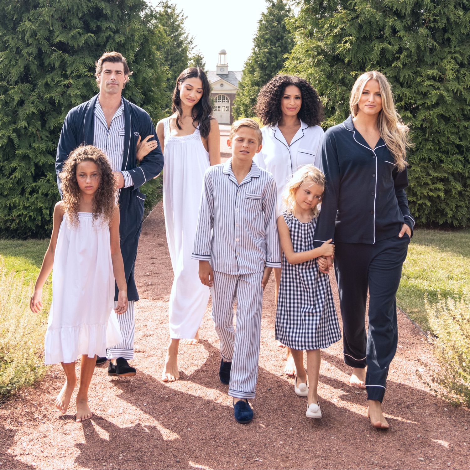 A group of people outside in blue and white matching pajamas walking on a gravel path