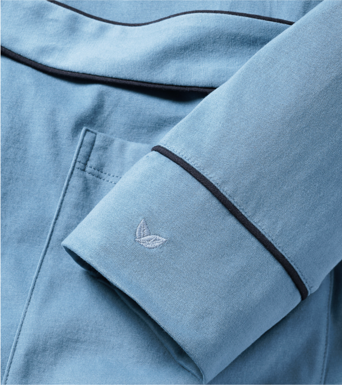 Close up of blue pajama sleeve, embroidered with feather