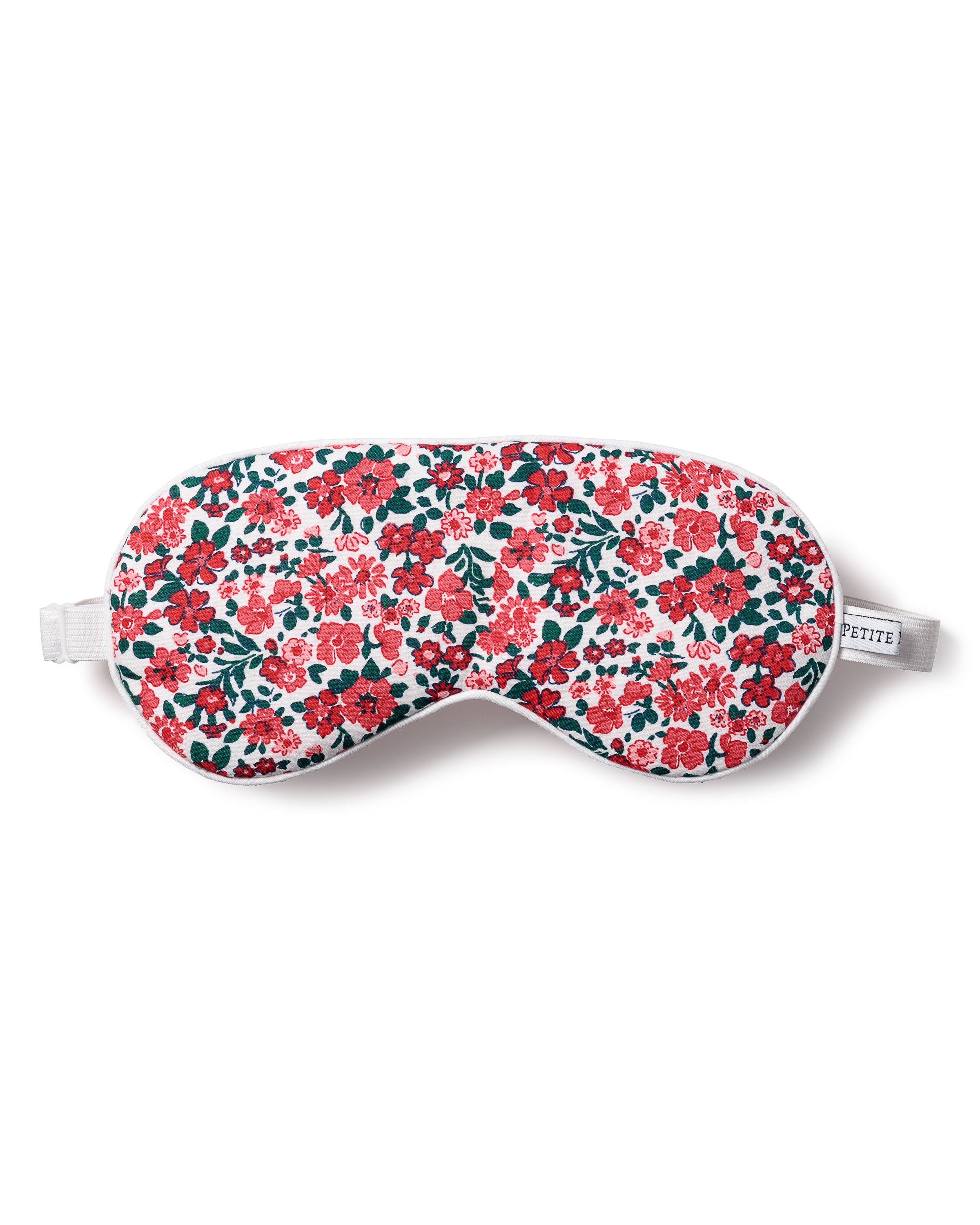 The Adults Twill Sleep Mask in Fleurs des Bois by Petite Plume showcases a vibrant floral pattern of red, pink, and dark green on white. It features a white elastic strap and a small fabric tag, making it an ideal gift for relaxation.