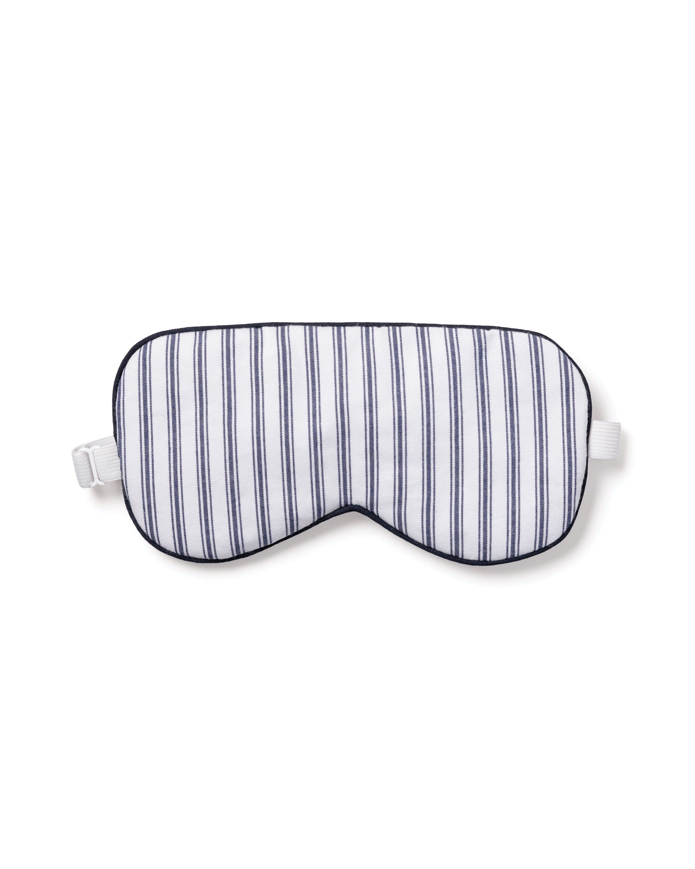 The Adults Twill Sleep Mask in Navy French Ticking by Petite Plume features white and navy stripes, black edges, and an elastic strap. Ideal for a luxury sleep experience, its perfect for monogrammed gifting to someone special.