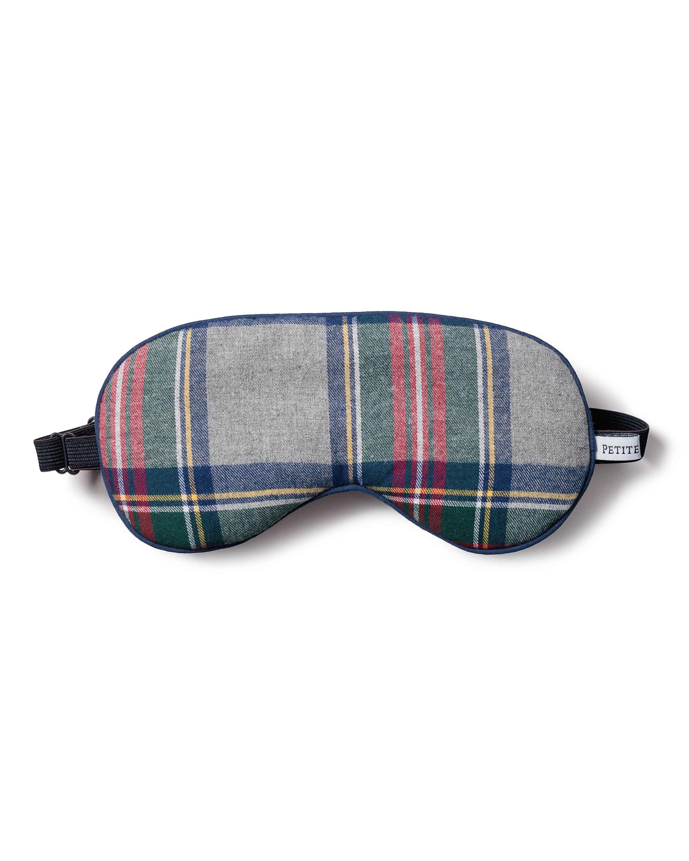 The Petite Plume Adults Brushed Cotton Sleep Mask in Westminster Tartan showcases a Scottish-inspired green, red, white, and gray plaid. Crafted from soft cotton twill with a black elastic strap and a small side tag.
