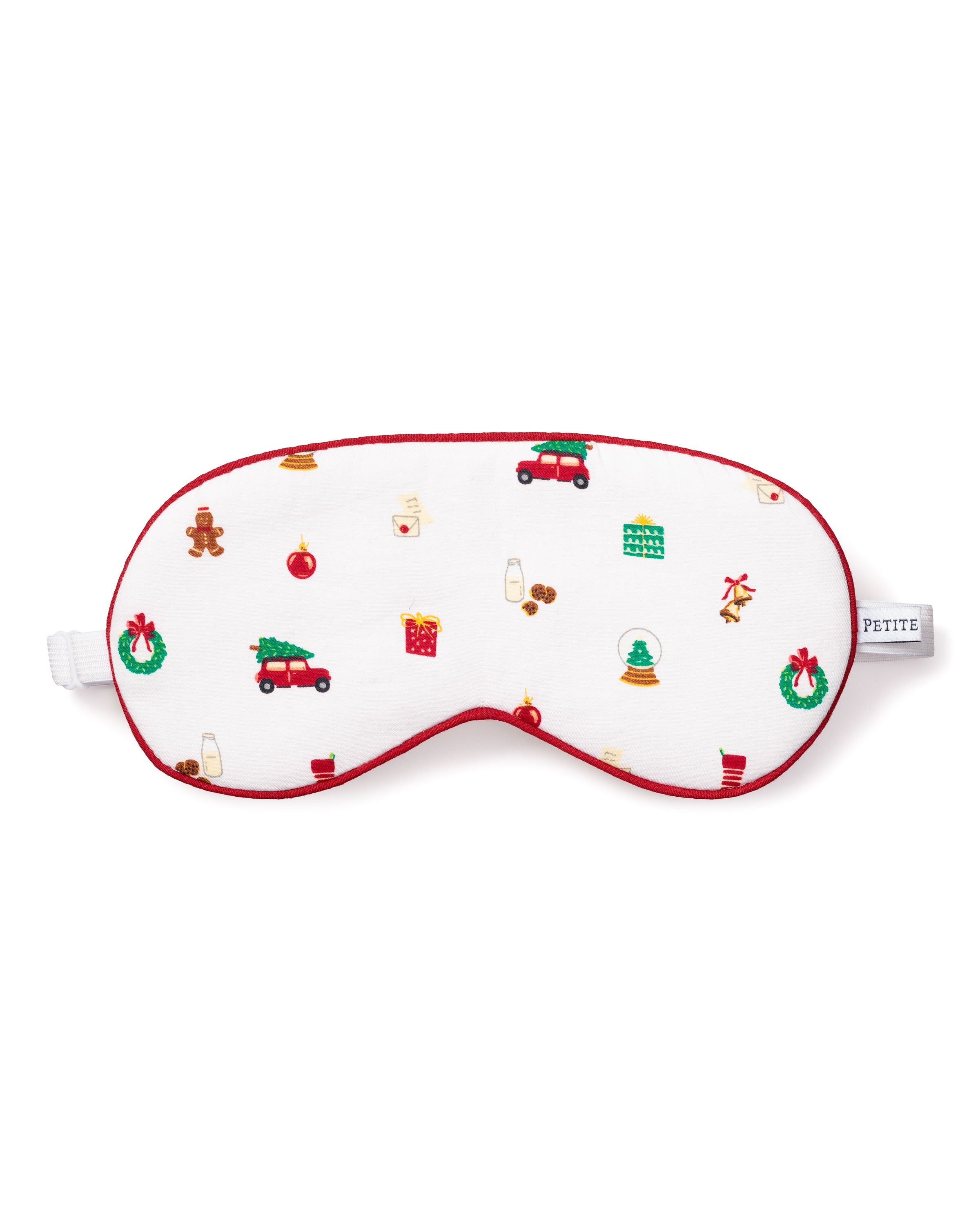 The Adults Twill Sleep Mask in Winter Nostalgia by Petite Plume, adorned with holiday illustrations such as gingerbread men and Christmas trees on white fabric with red trim, is perfect for a luxury sleepover. Add matching eye masks to enhance your holiday spirit collection.