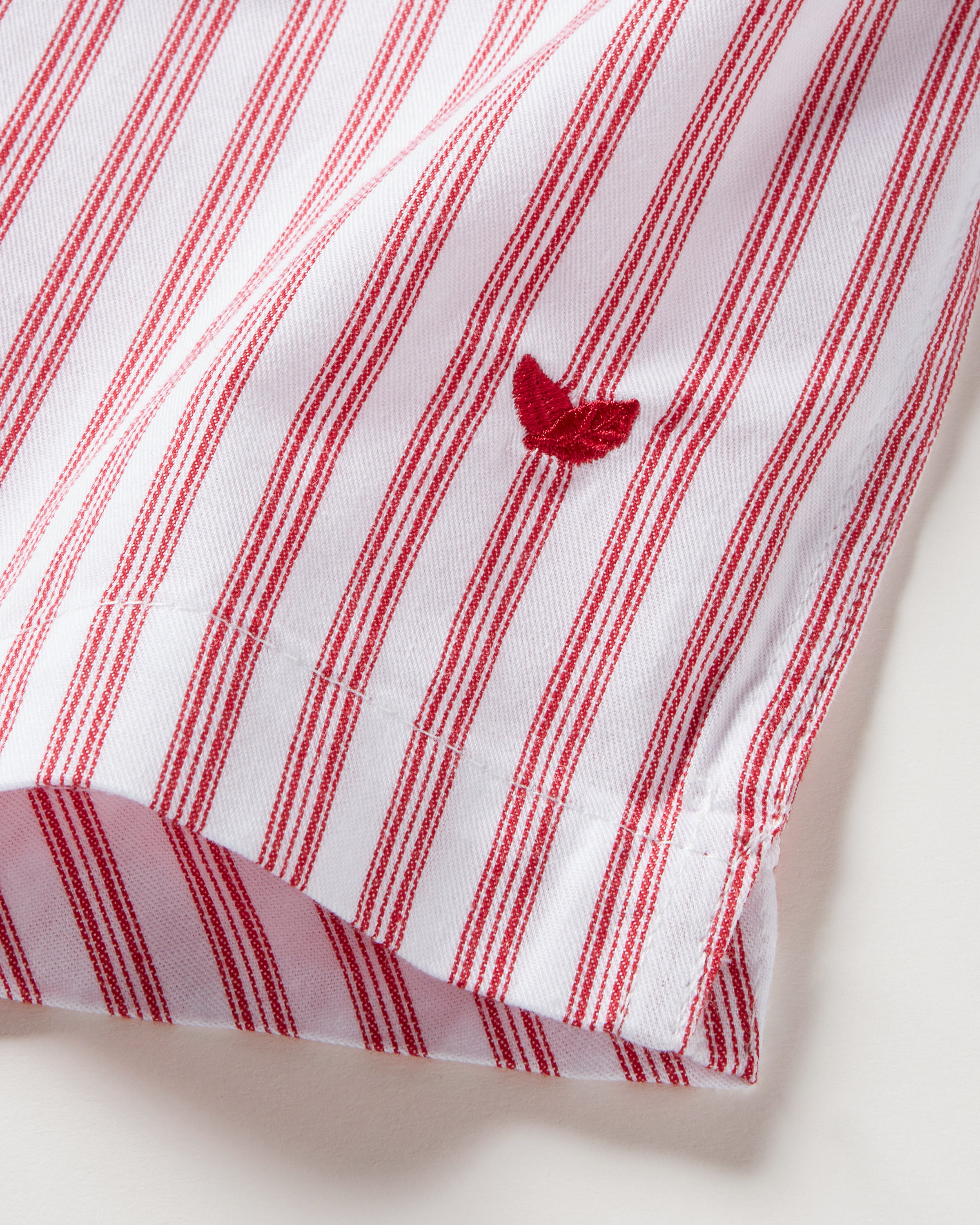 A close-up shows the Mens Twill 3 Pack Boxers in Holiday Red by Petite Plume featuring red and white vertical stripes on soft, lightweight woven cotton twill. A folded edge displays a small red bird-like embroidered logo, reminiscent of a classic fit.