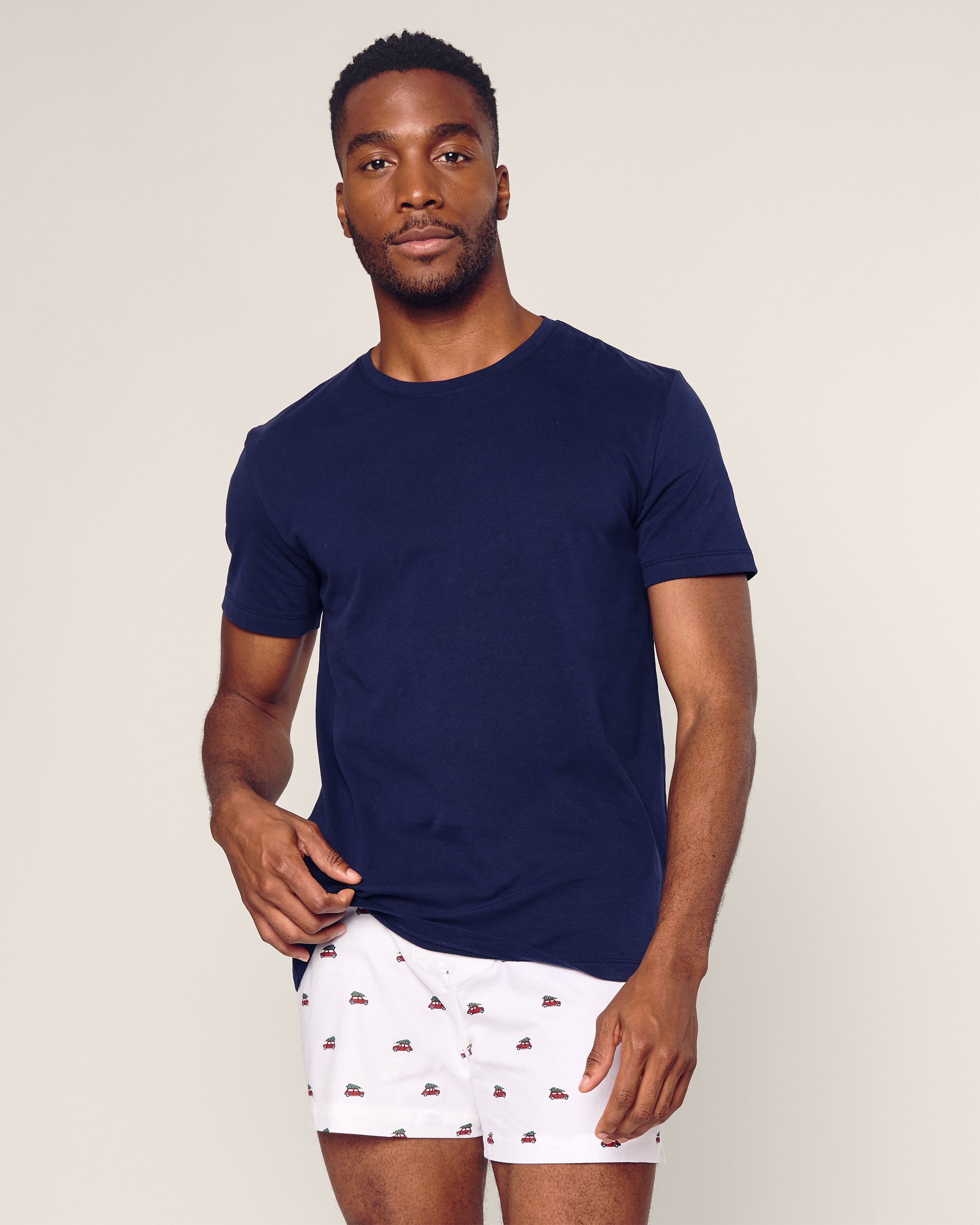 A man stands against a light background wearing Petite Plume Mens Twill 3 Pack Boxers in Windsor Tartan, featuring an elastic waistband and soft woven cotton twill, looking toward the camera with a neutral expression.