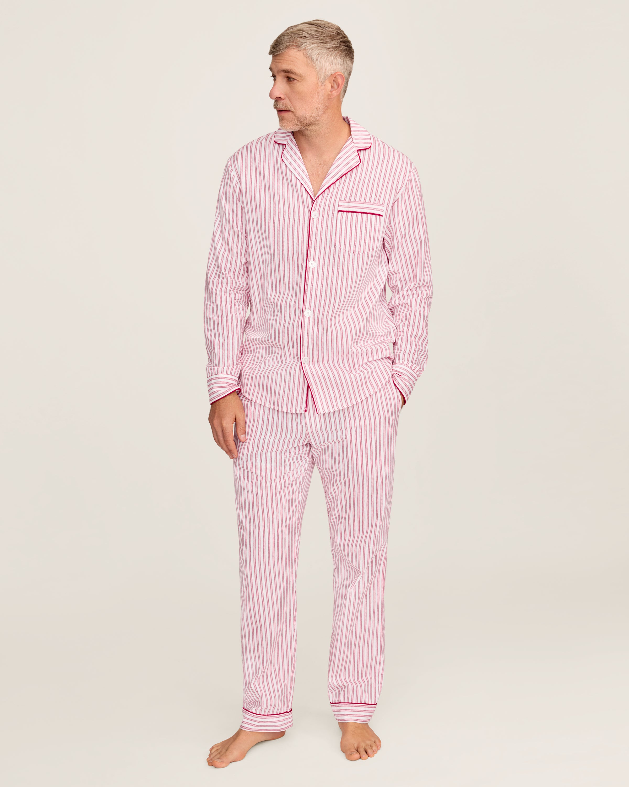 Close-up of Petite Plumes Mens Twill Pajama Set in Antique Red Ticking, featuring pink and white vertical stripes, a collar, a pocket with matching trim, and a single white button. Perfect for cozy relaxation.