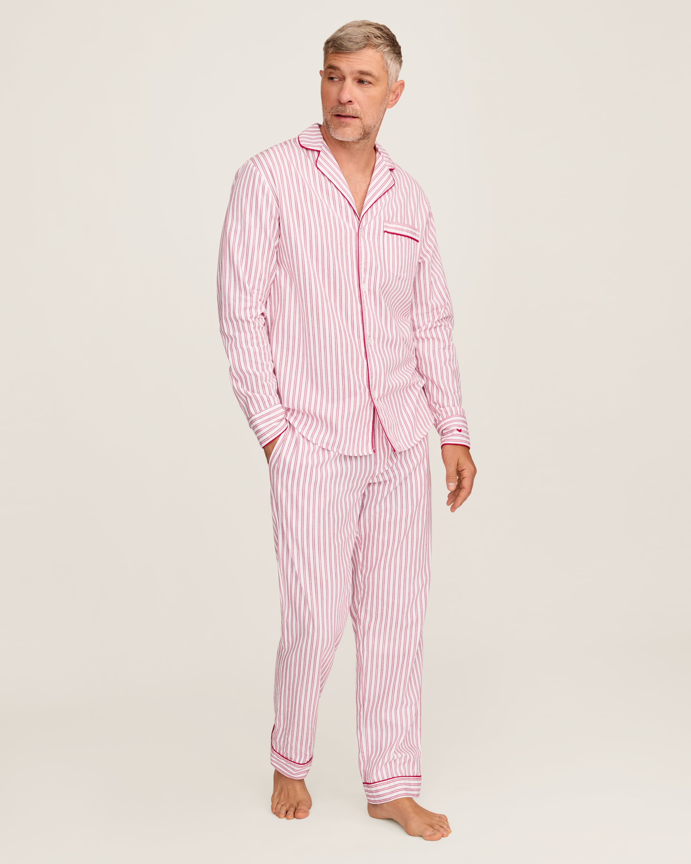 Close-up of Petite Plumes Mens Twill Pajama Set in Antique Red Ticking, featuring pink and white vertical stripes, a collar, a pocket with matching trim, and a single white button. Perfect for cozy relaxation.