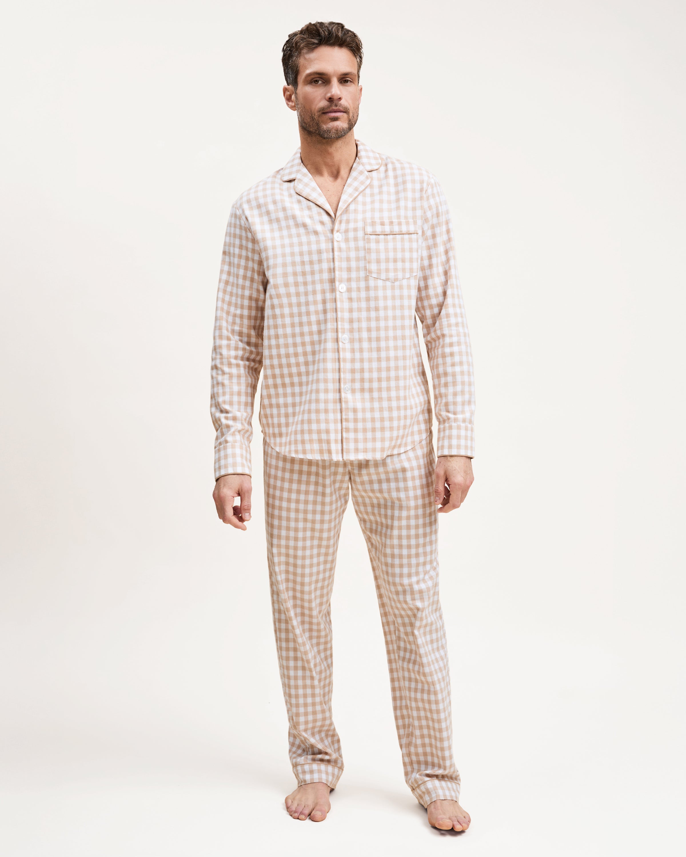 The Men's Twill Pajama Set in Camel Gingham includes a long-sleeve, button-up top with a chest pocket and matching pants, both in a beige and white gingham check pattern.