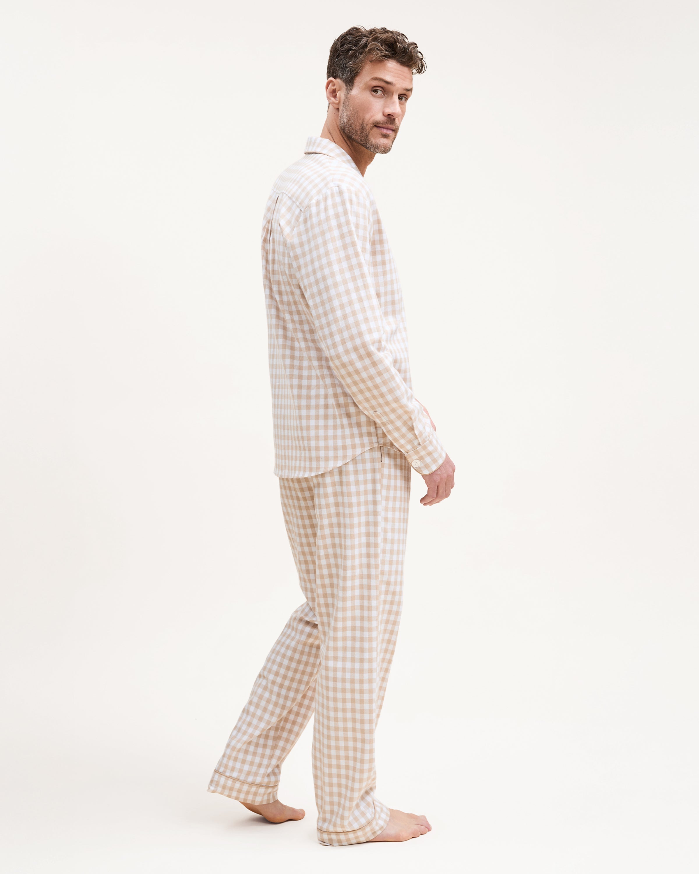 The Men's Twill Pajama Set in Camel Gingham includes a long-sleeve, button-up top with a chest pocket and matching pants, both in a beige and white gingham check pattern.