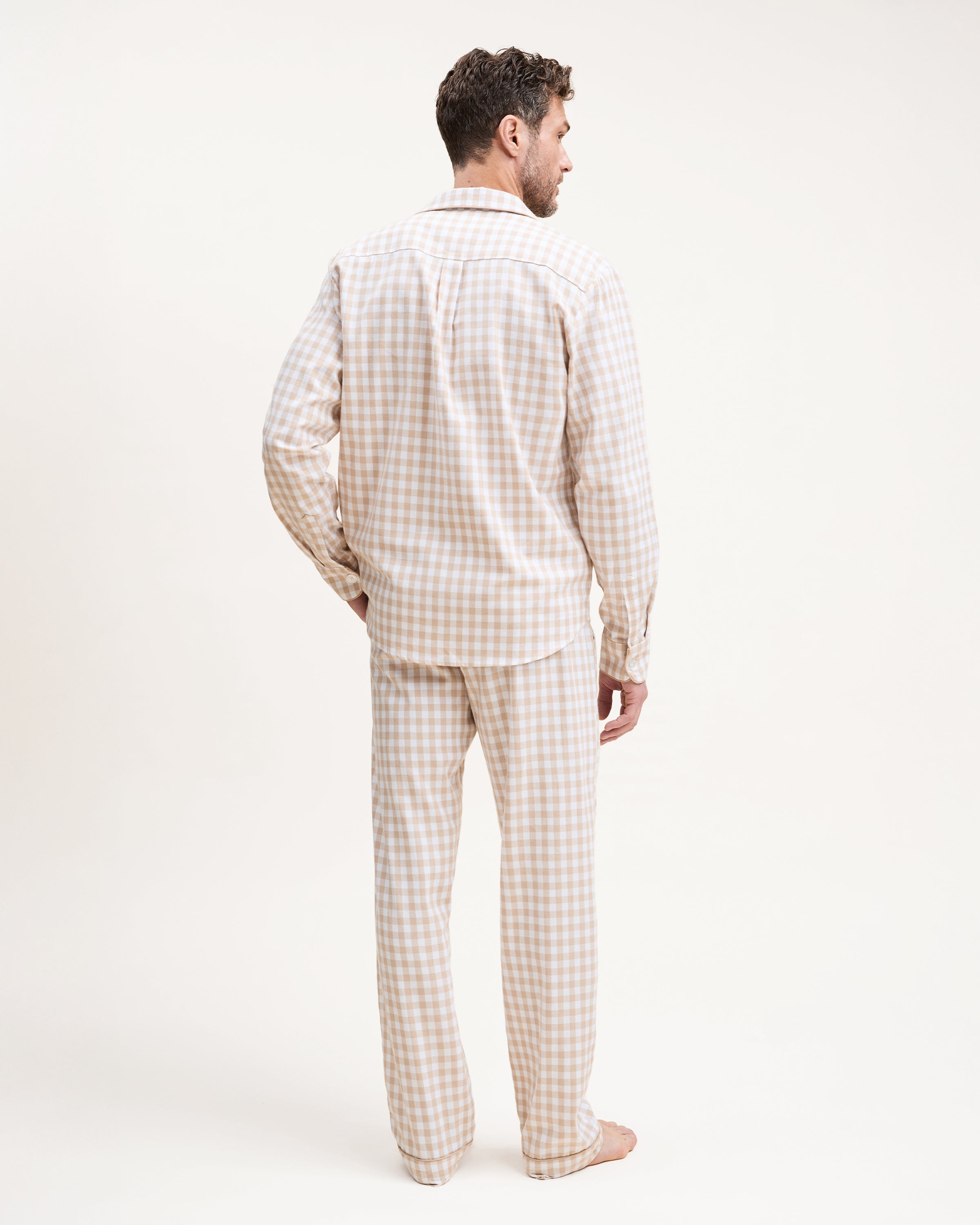 The Men's Twill Pajama Set in Camel Gingham includes a long-sleeve, button-up top with a chest pocket and matching pants, both in a beige and white gingham check pattern.