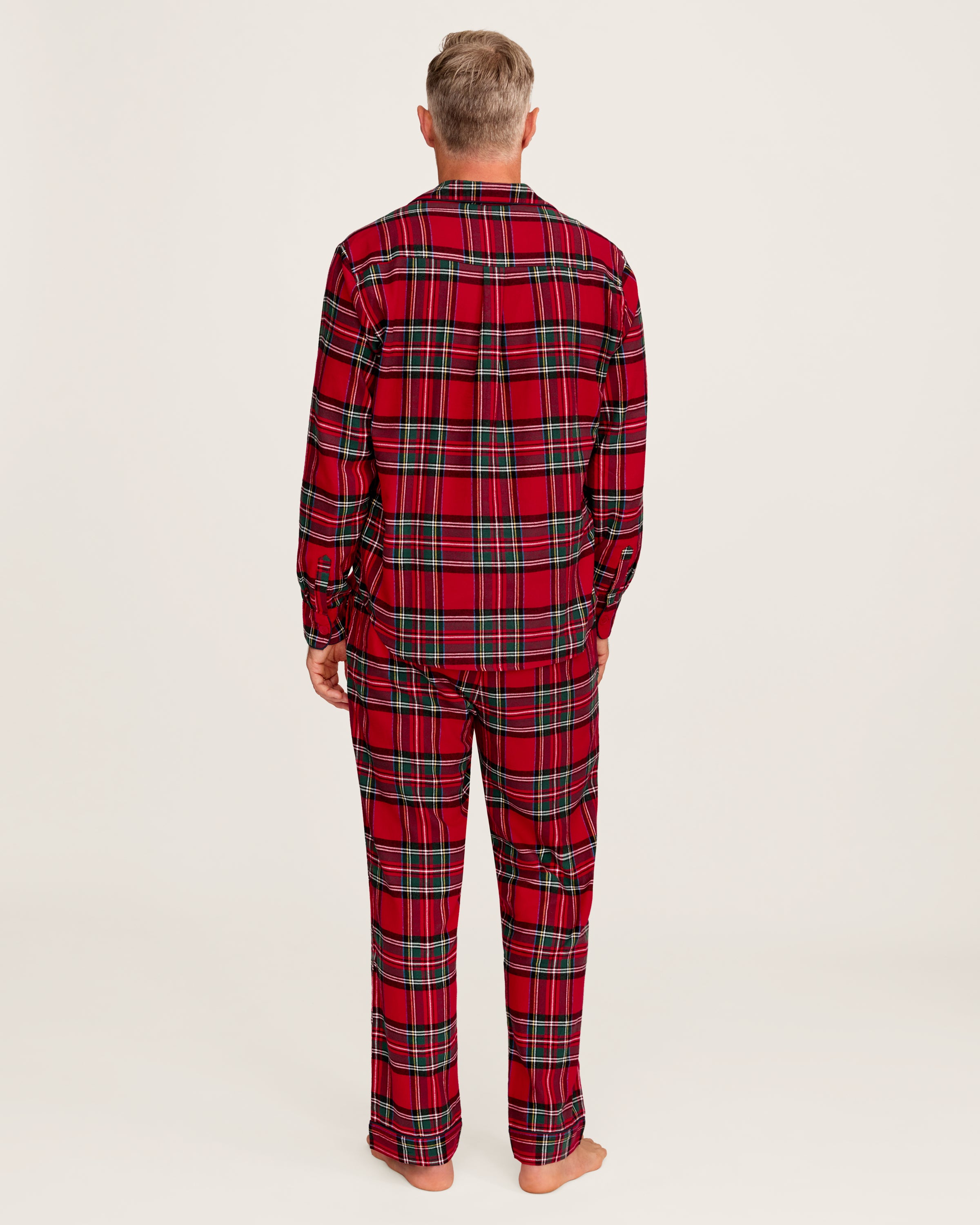 The Men's Brushed Twill Pajama Set in Imperial Tartan features a red plaid design with green, white, and black stripes, a button-up long-sleeve top with a chest pocket, and matching pants, displayed neatly on a white background.