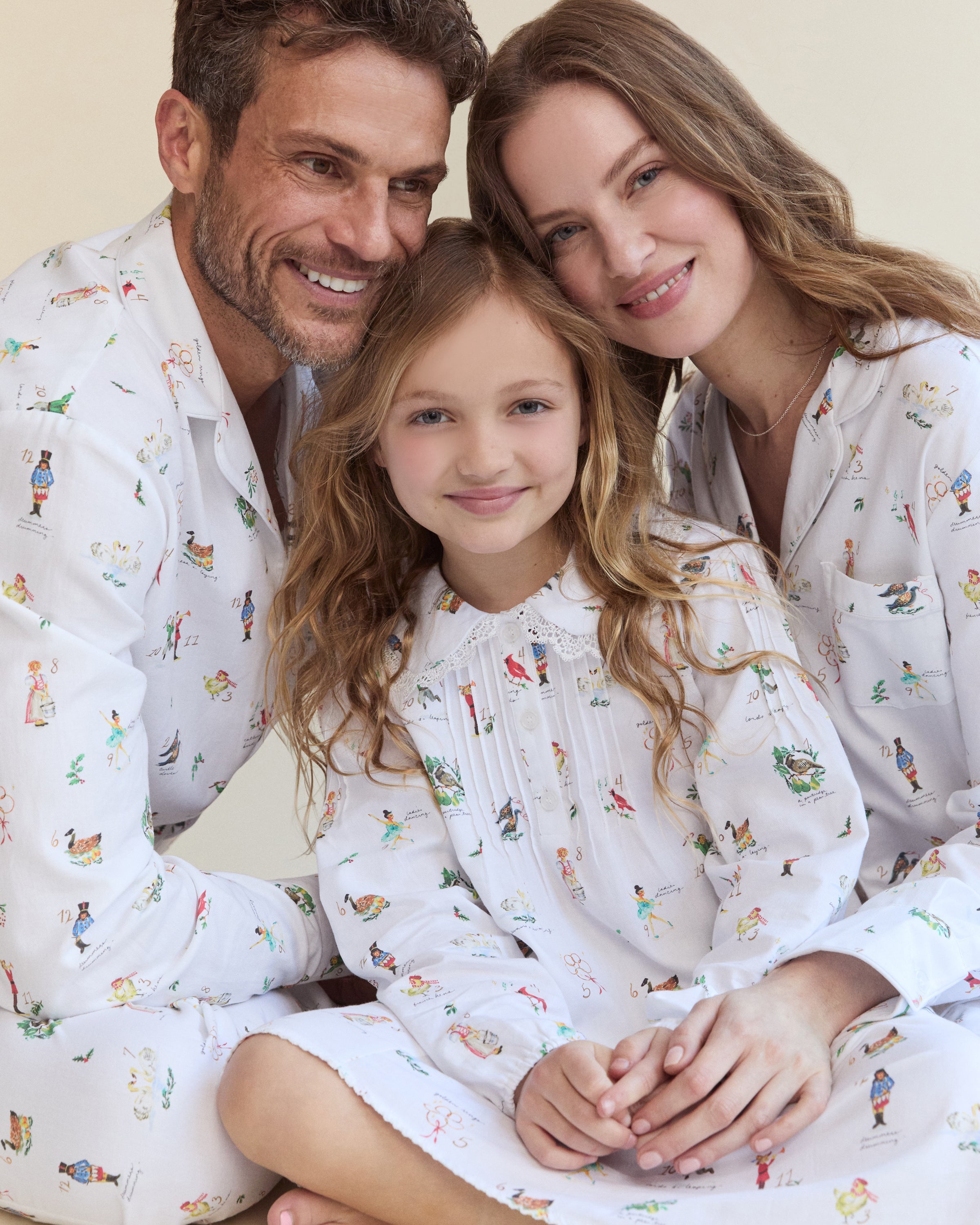 Men's Twill Pajama Set in 12 Days of Christmas: white button-up top and matching pants with a festive print featuring playful animals, palm trees, and people in various poses scattered across the fabric.