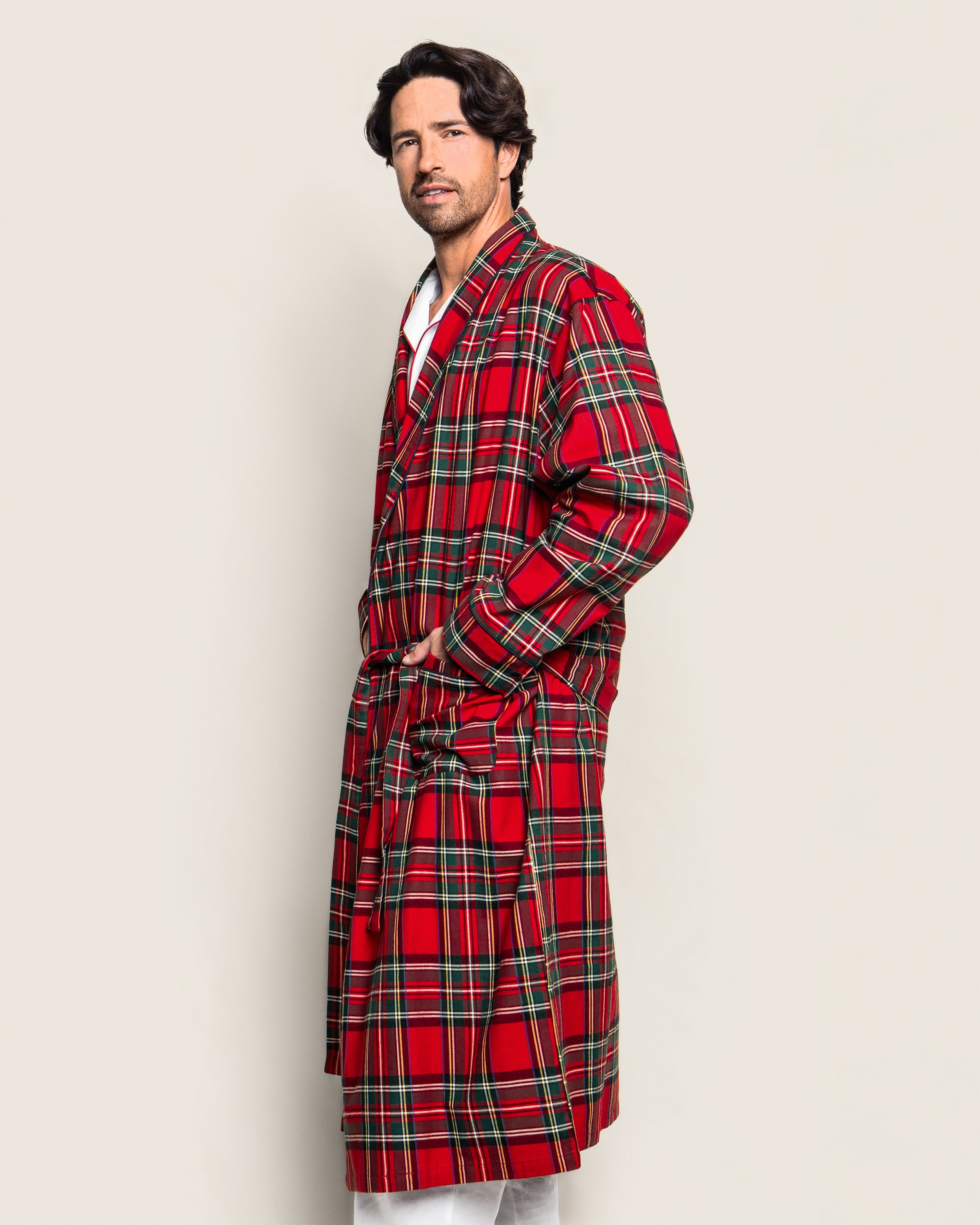 An individual models the Mens Brushed Cotton Robe in Imperial Tartan by Petite Plume, against a plain light background, featuring green and yellow accents with their hand in a spacious pocket.
