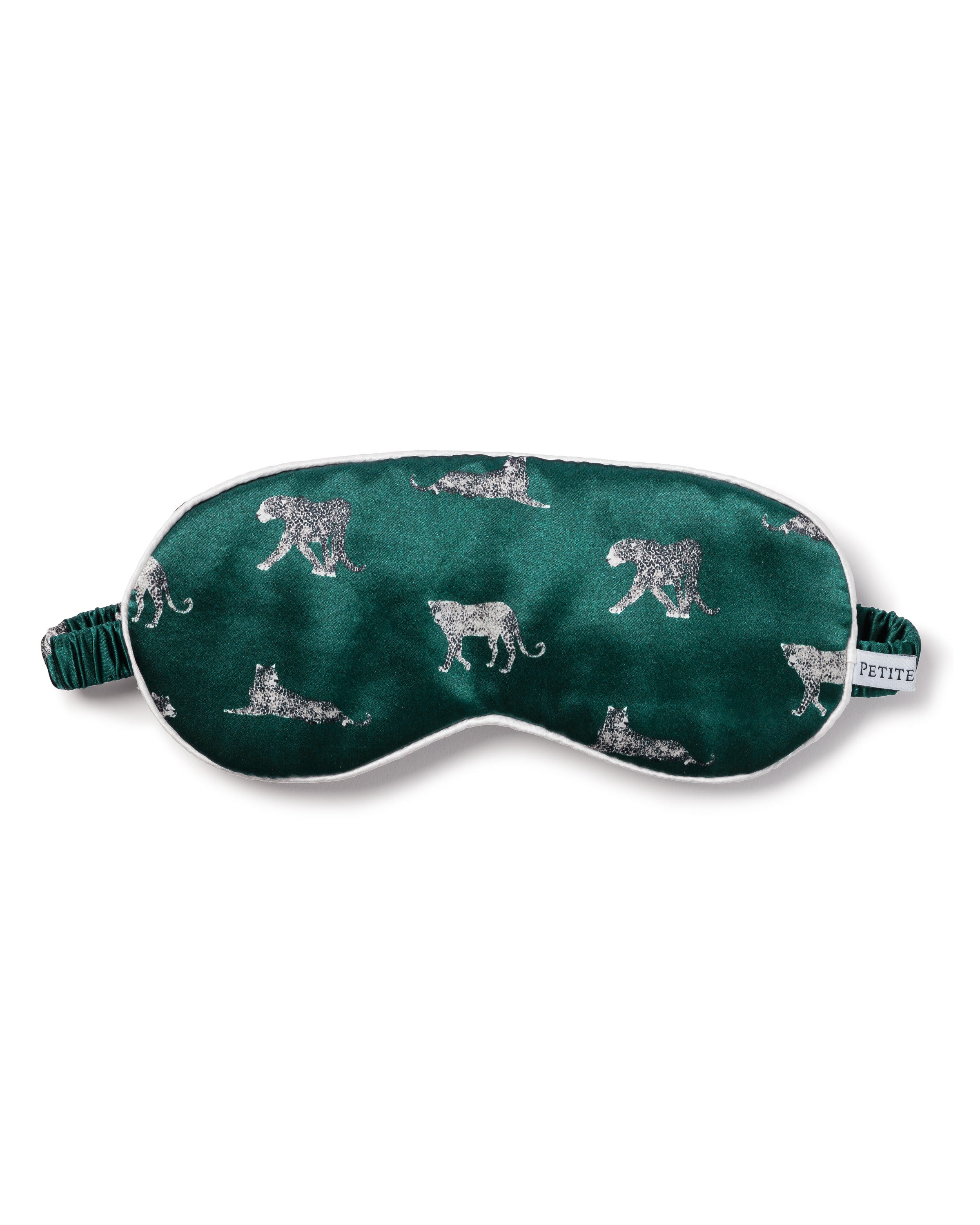 Experience luxurious slumber with the Adults Silk Sleep Mask in Panthère de Luxe by Petite Plume, featuring detailed white leopard sketches on a green backdrop. It includes an elastic strap and a small white tag for added comfort.