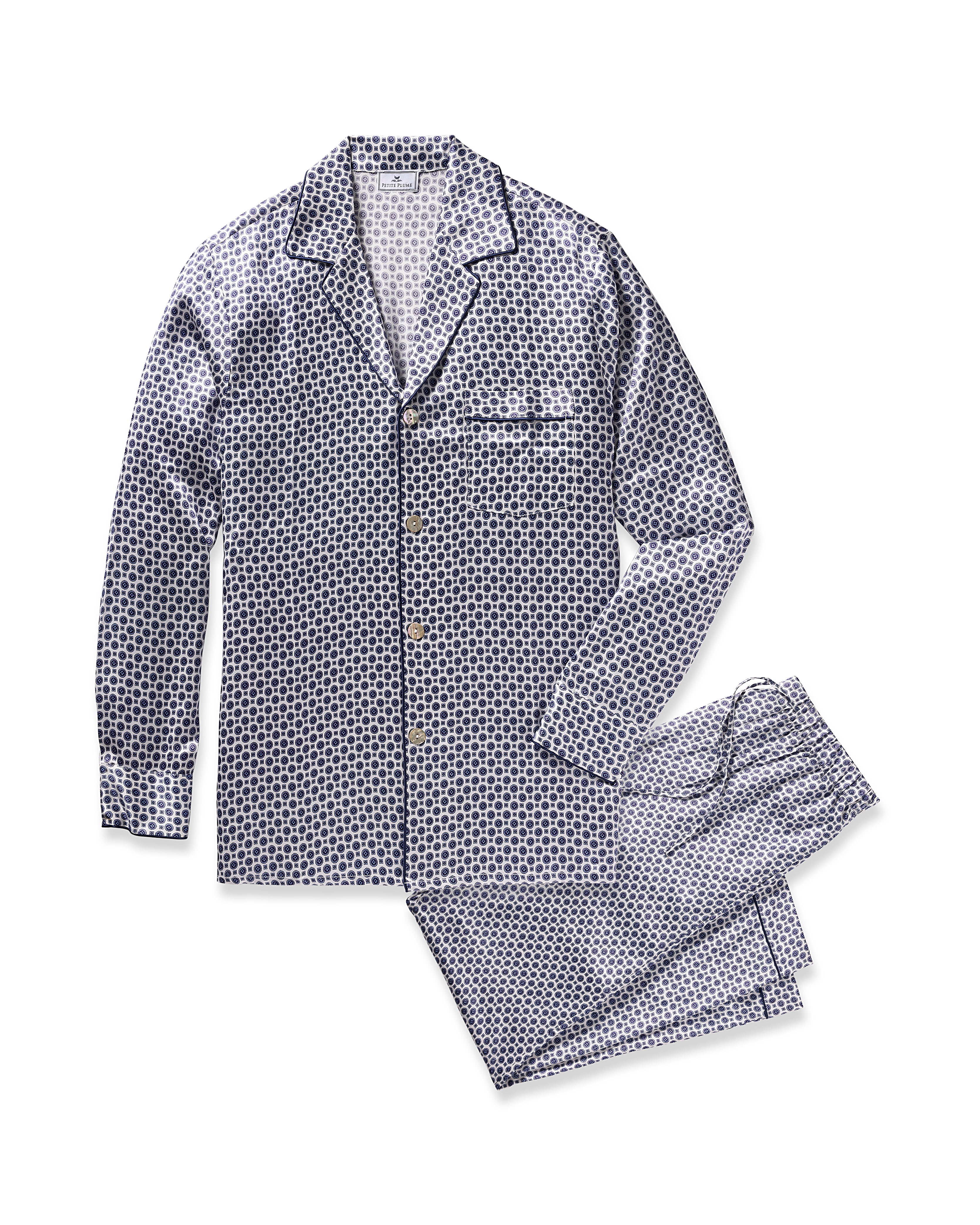 The Mens Silk Pajama Set in Navy Foulard by Petite Plume features a button-up long-sleeve top with a small pocket and pants. Made from mulberry silk, it showcases a blue and white geometric pattern, adding elegance and comfort to your sleepwear collection.