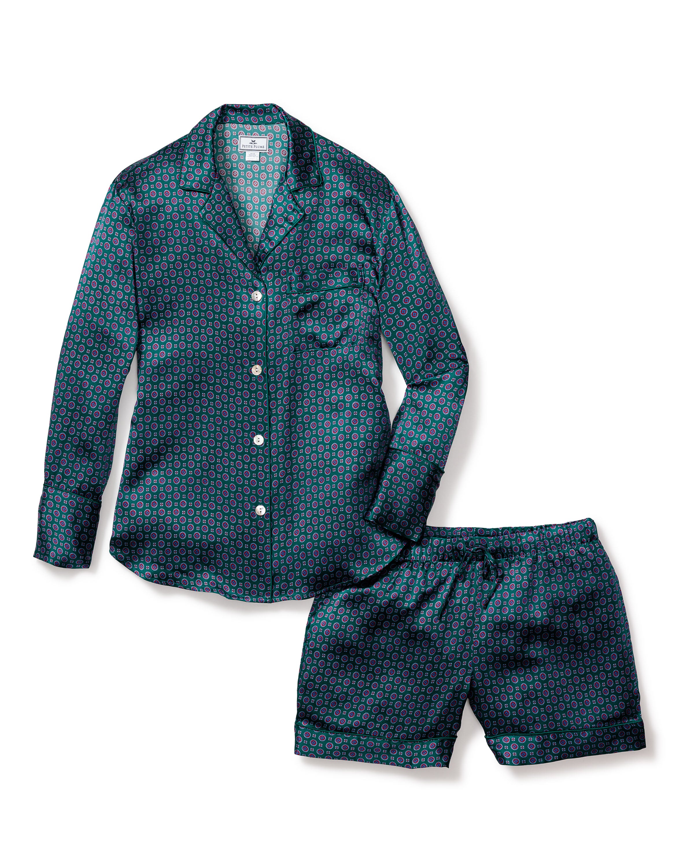 The Womens Silk Long Sleeve Short Set in Emerald Foulard by Petite Plume features a classic pajama look with a teal circular pattern, button-up top, breast pocket, and elastic waistband for comfort.