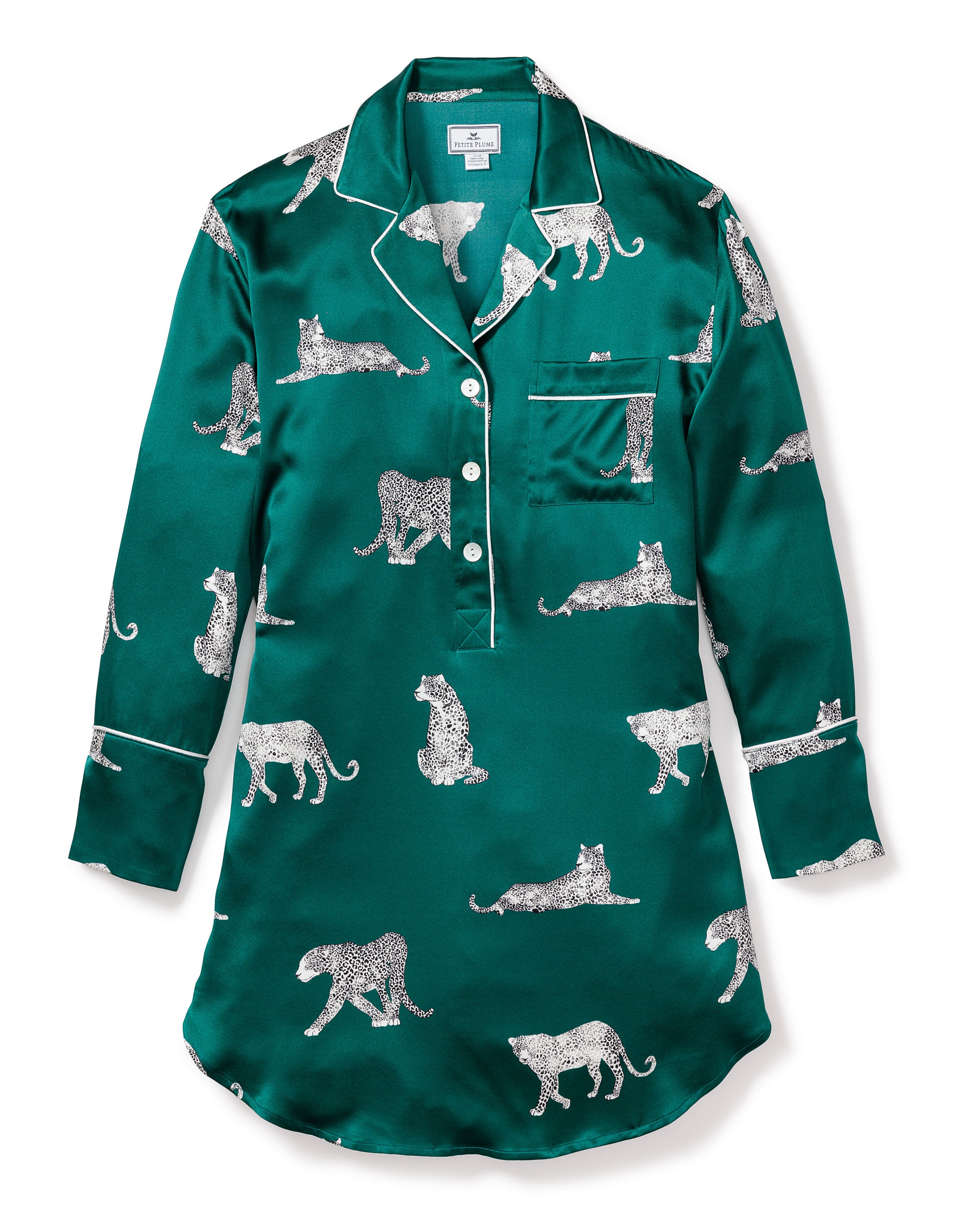 Introducing Petite Plumes luxurious Womens Silk Nightshirt in Panthère de Luxe: a green, long-sleeved mulberry silk pajama shirt with elegant white piping, button-down front, and a chest pocket. The fabric features an enchanting pattern of white leopards in various poses.