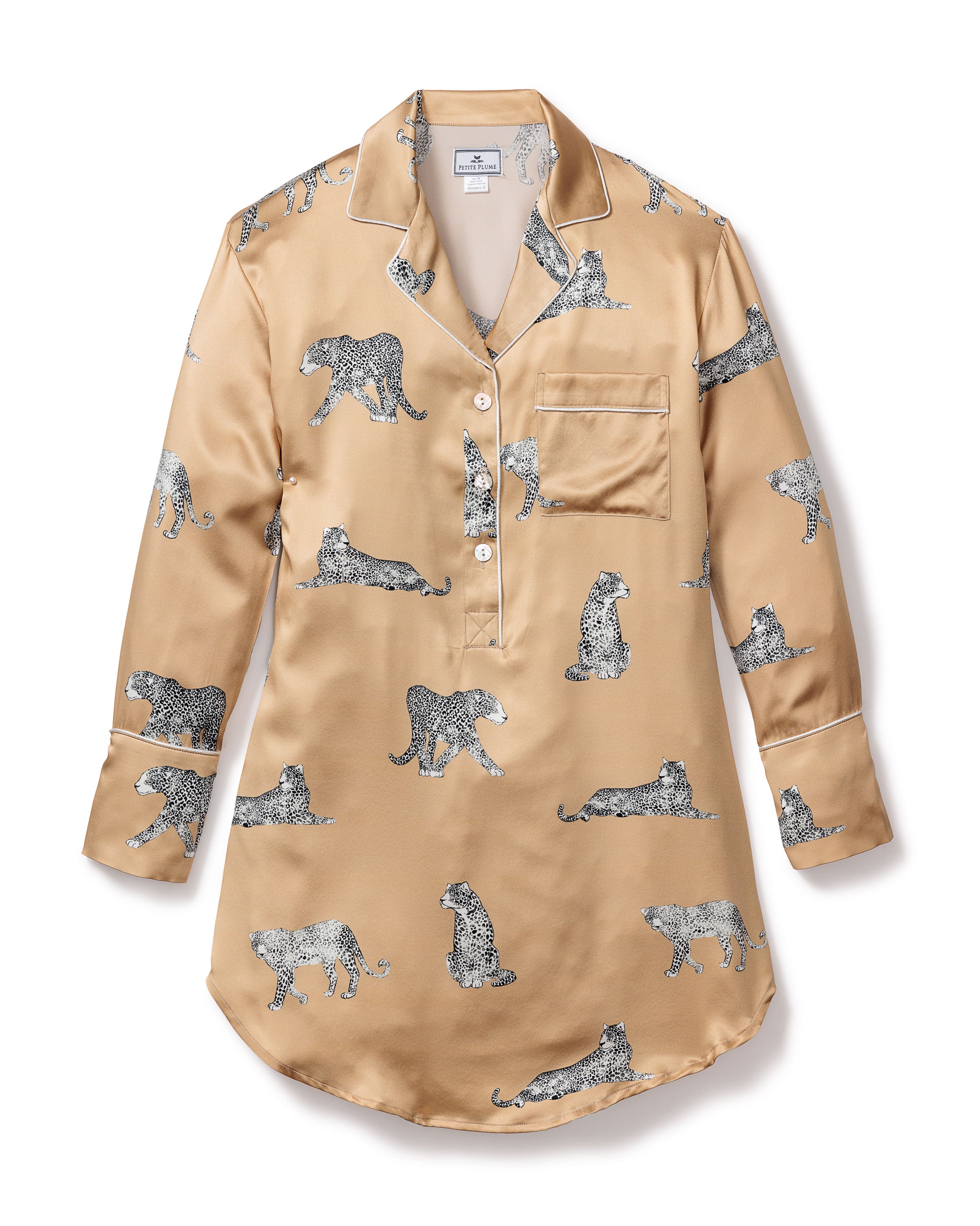 The Womens Silk Nightshirt in Panthère Champagne by Petite Plume is crafted from luxurious Mulberry silk. It features a beige hue with black and white leopard prints, a chest pocket, collar, and button-down front, offering both comfort and elegance for peaceful nights.