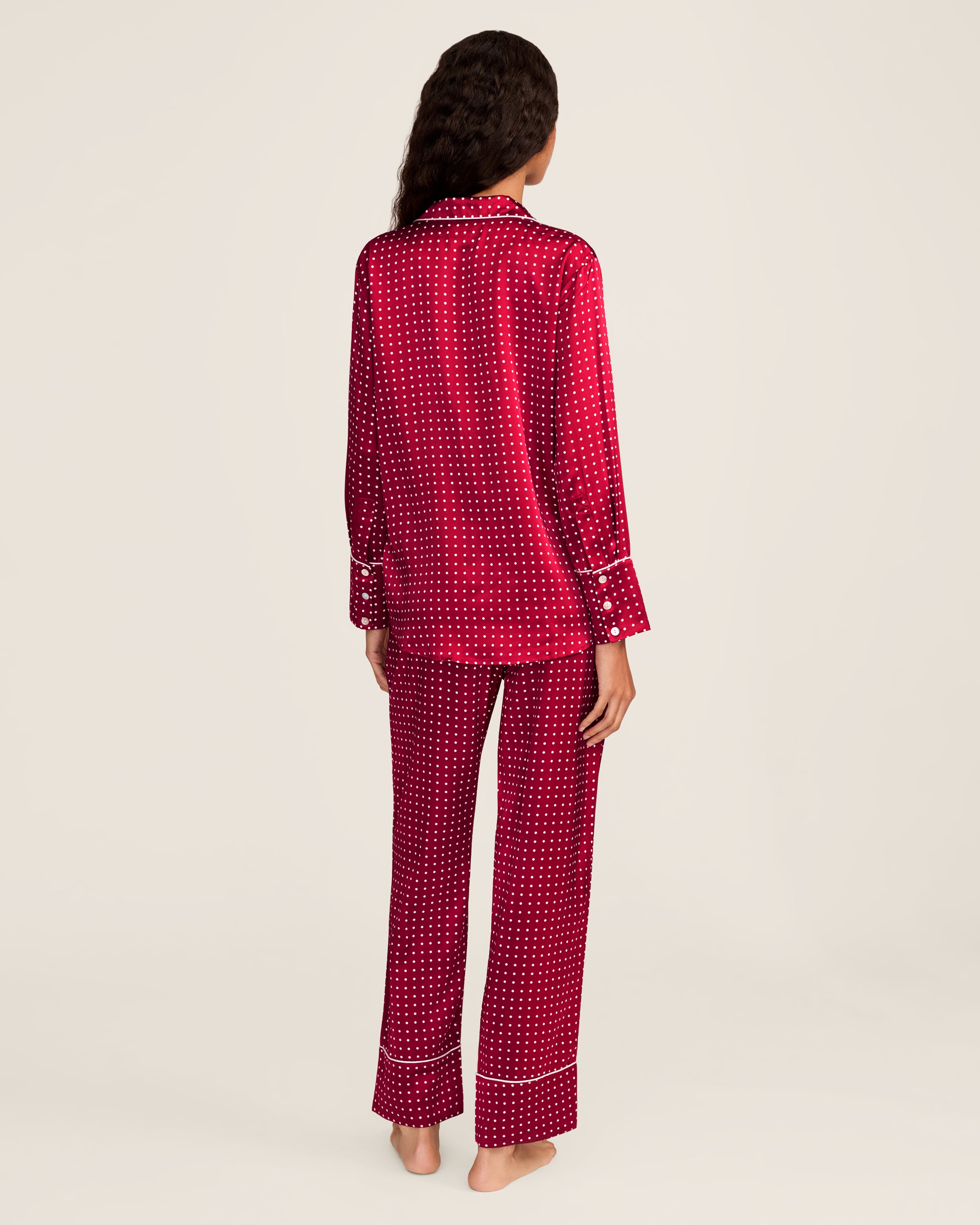 Experience luxury sleepwear with Petite Plumes Womens Silk Pajama Set in Bordeaux Polka Dot, featuring a bright red button-up long-sleeve top with white dots and piping, crafted from breathable mulberry silk, paired with matching pants.