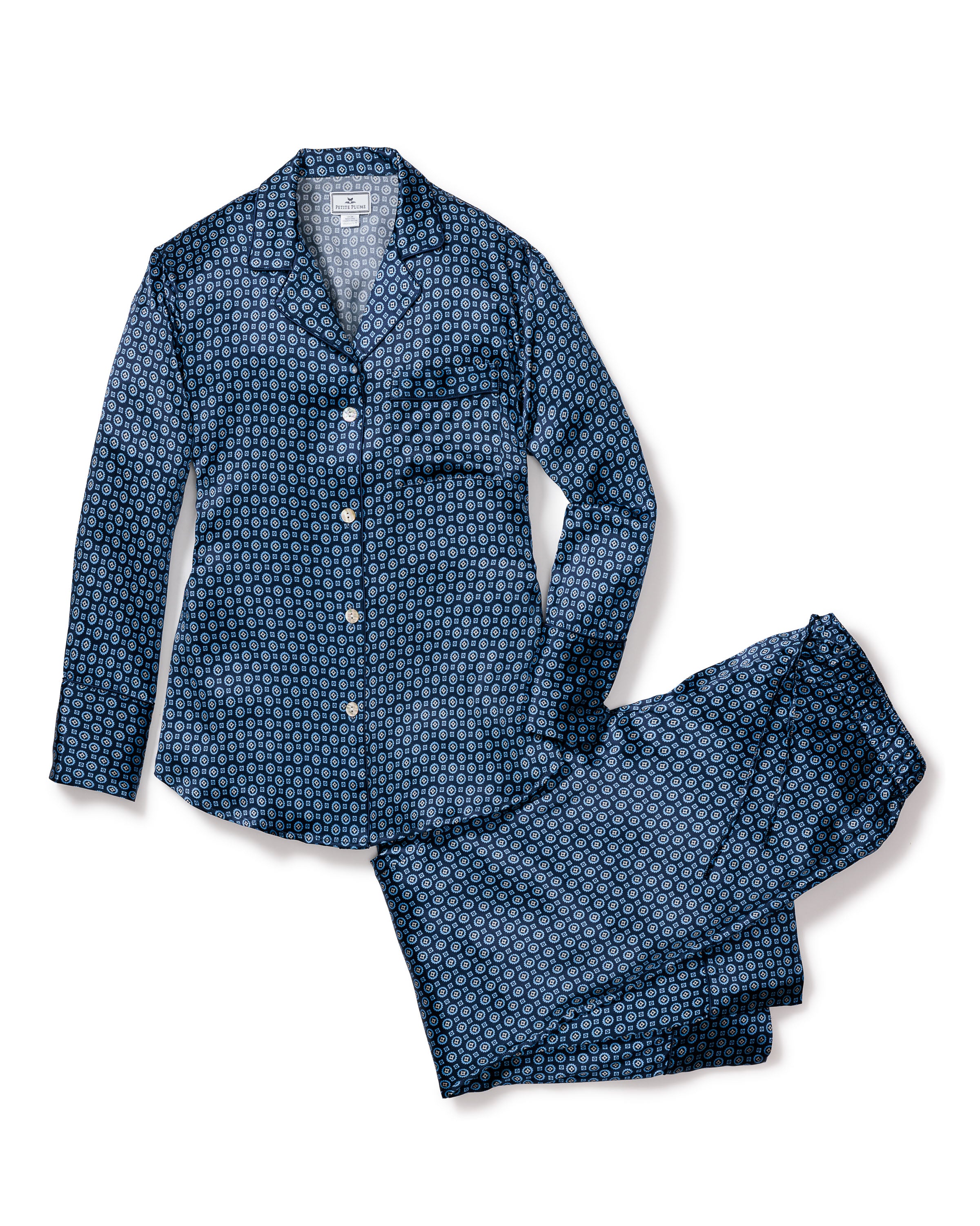 Petite Plumes Womens Silk Pajama Set in Midnight Foulard features a geometric circular design, made from Mulberry silk. This luxury sleepwear includes a long-sleeved button-up shirt with a chest pocket and matching pants, offering a relaxed look and temperature regulation for comfort.
