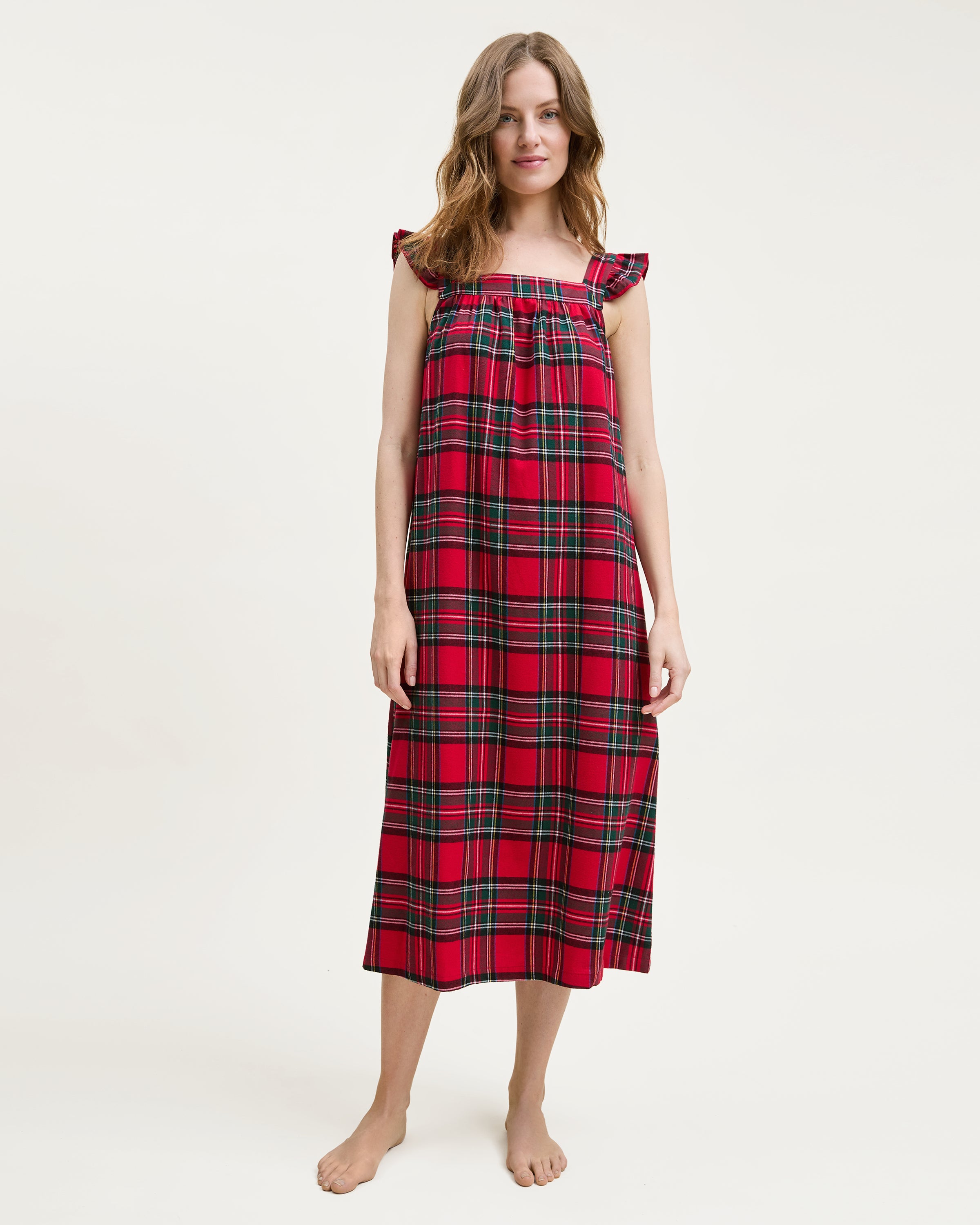 The Women's Brushed Twill Clara Nightgown in Imperial Tartan features a sleeveless red plaid design with green, yellow, and white stripes, ruffled shoulder straps, and a loose gathered bodice for a festive holiday look.