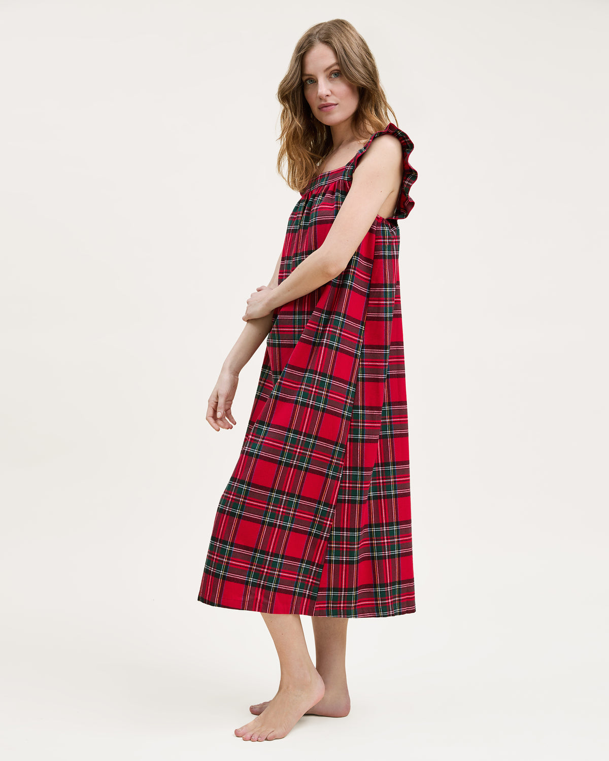 The Women's Brushed Twill Clara Nightgown in Imperial Tartan features a sleeveless red plaid design with green, yellow, and white stripes, ruffled shoulder straps, and a loose gathered bodice for a festive holiday look.