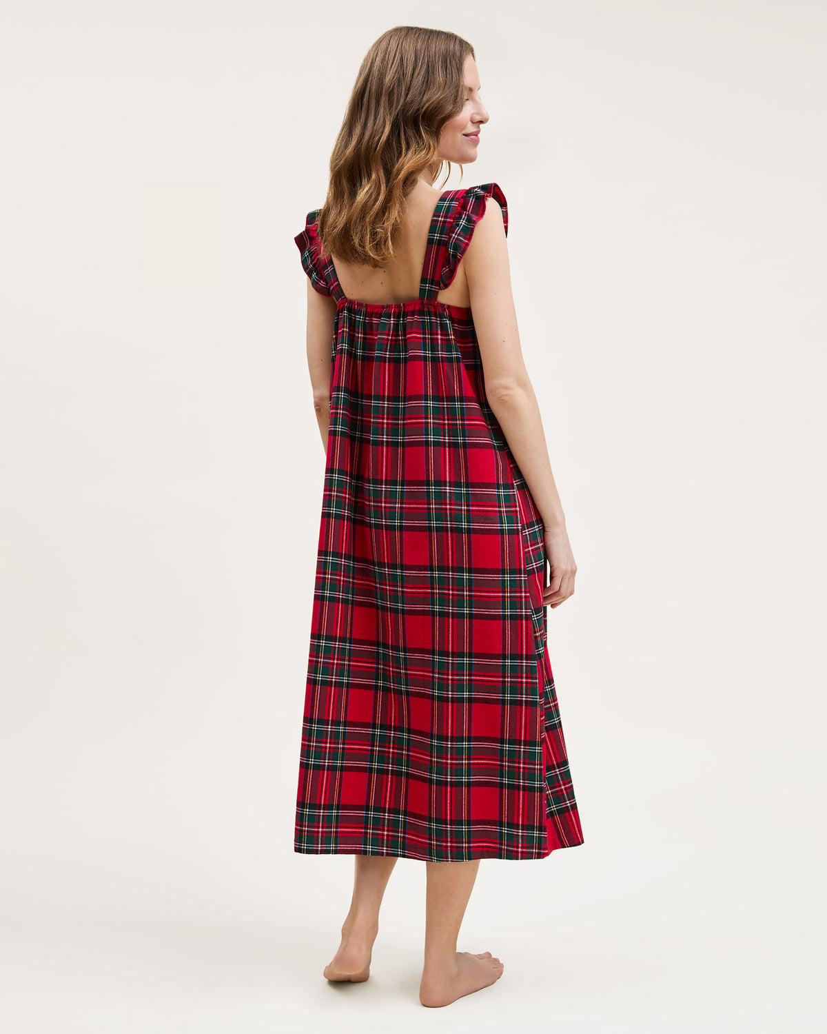 The Women's Brushed Twill Clara Nightgown in Imperial Tartan features a sleeveless red plaid design with green, yellow, and white stripes, ruffled shoulder straps, and a loose gathered bodice for a festive holiday look.