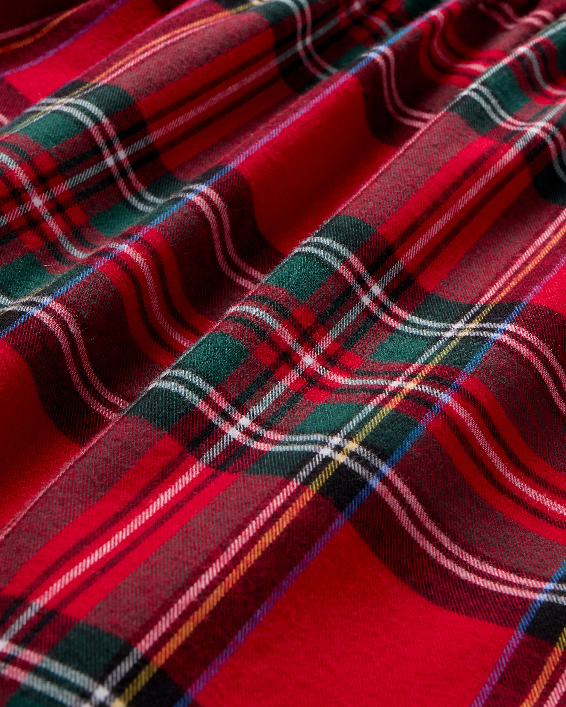 The Women's Brushed Twill Clara Short Set in Imperial Tartan features a red, green, white, and black plaid pattern with a sleeveless ruffled top and elastic-waist shorts, displayed flat on a white background.