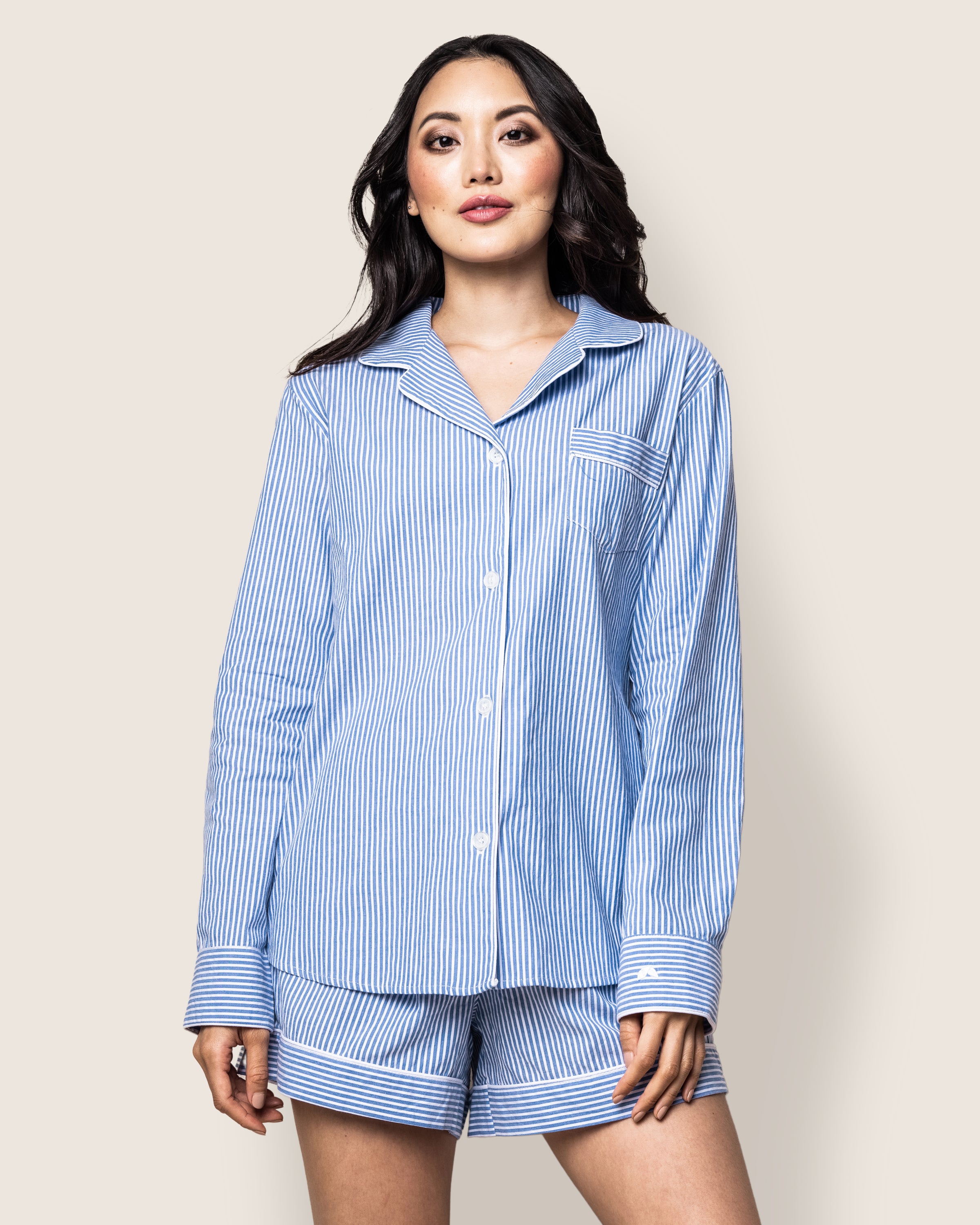 A woman in Petite Plumes Womens Twill Long Sleeve Short Set, featuring French Blue Seersucker stripes, stands against a plain background, looking forward.