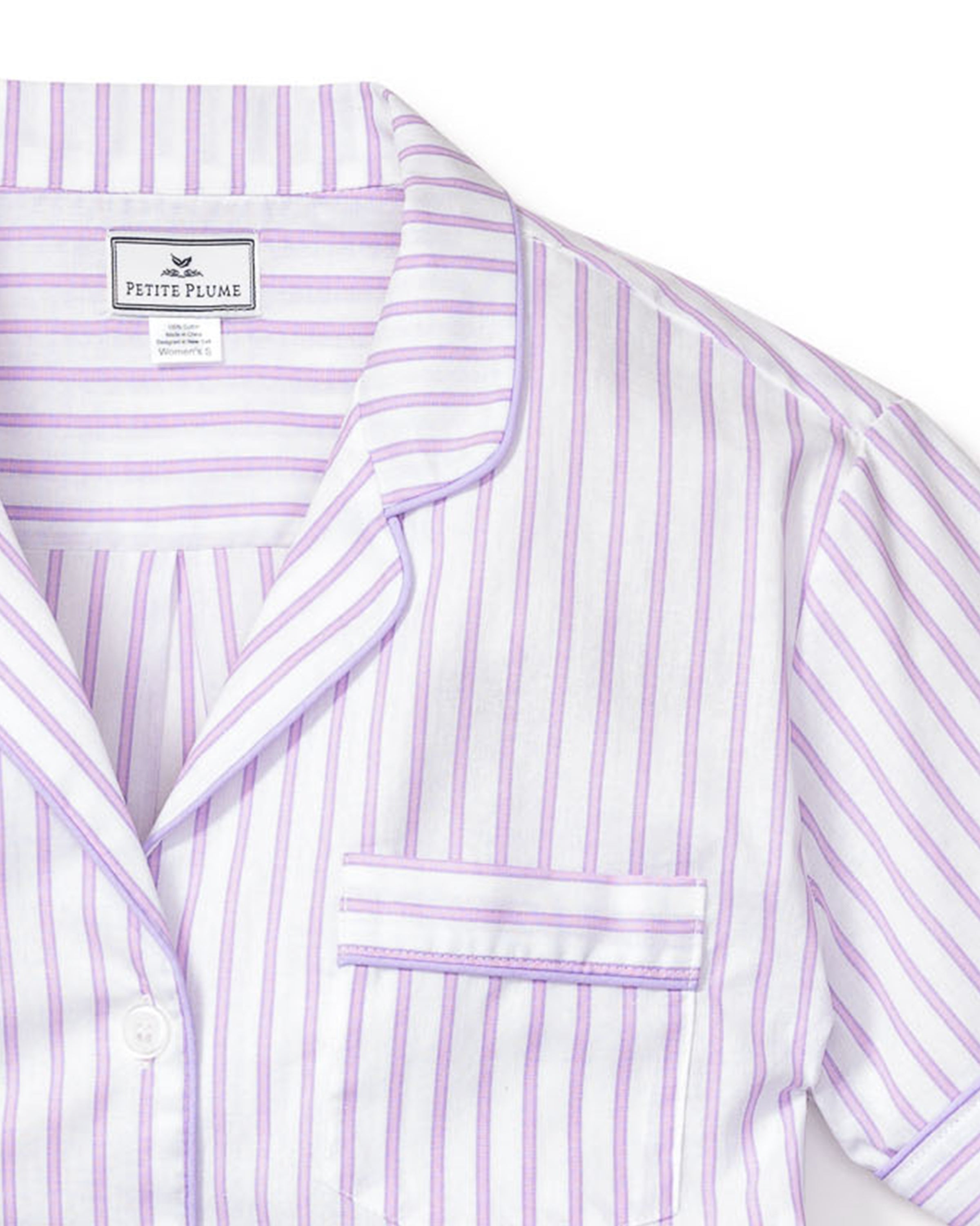 This Petite Plume luxury sleepwear features a white button-up shirt with lavender stripes, a chest pocket, notched collar with lavender piping, and an interior fabric label.