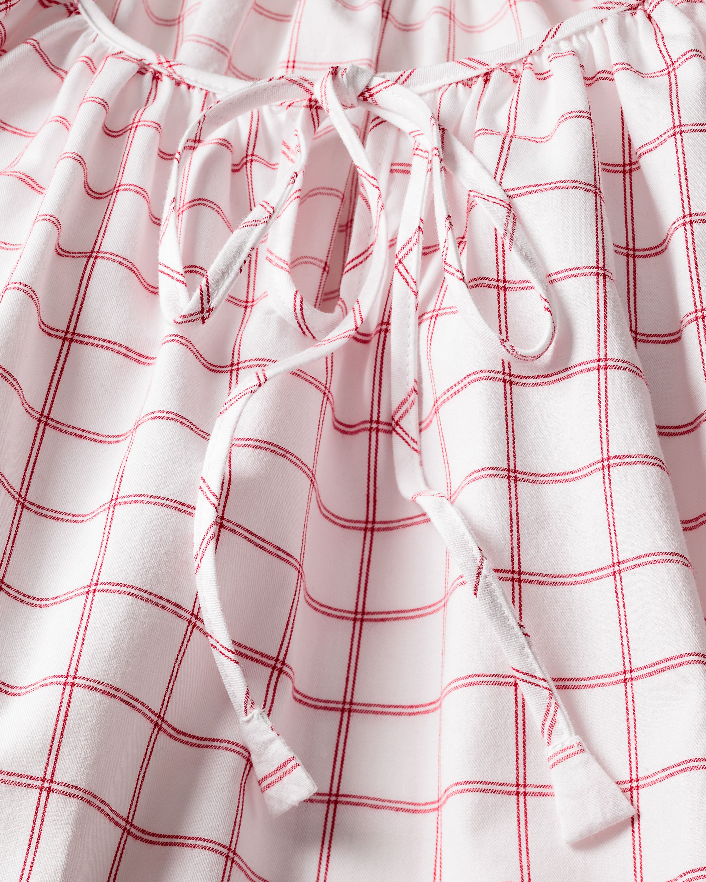 Close-up of Petite Plumes Womens Twill Delphine Nightgown in a garnet tattersall pattern. The cotton twill fabric showcases red grid lines on white with visible white drawstrings.