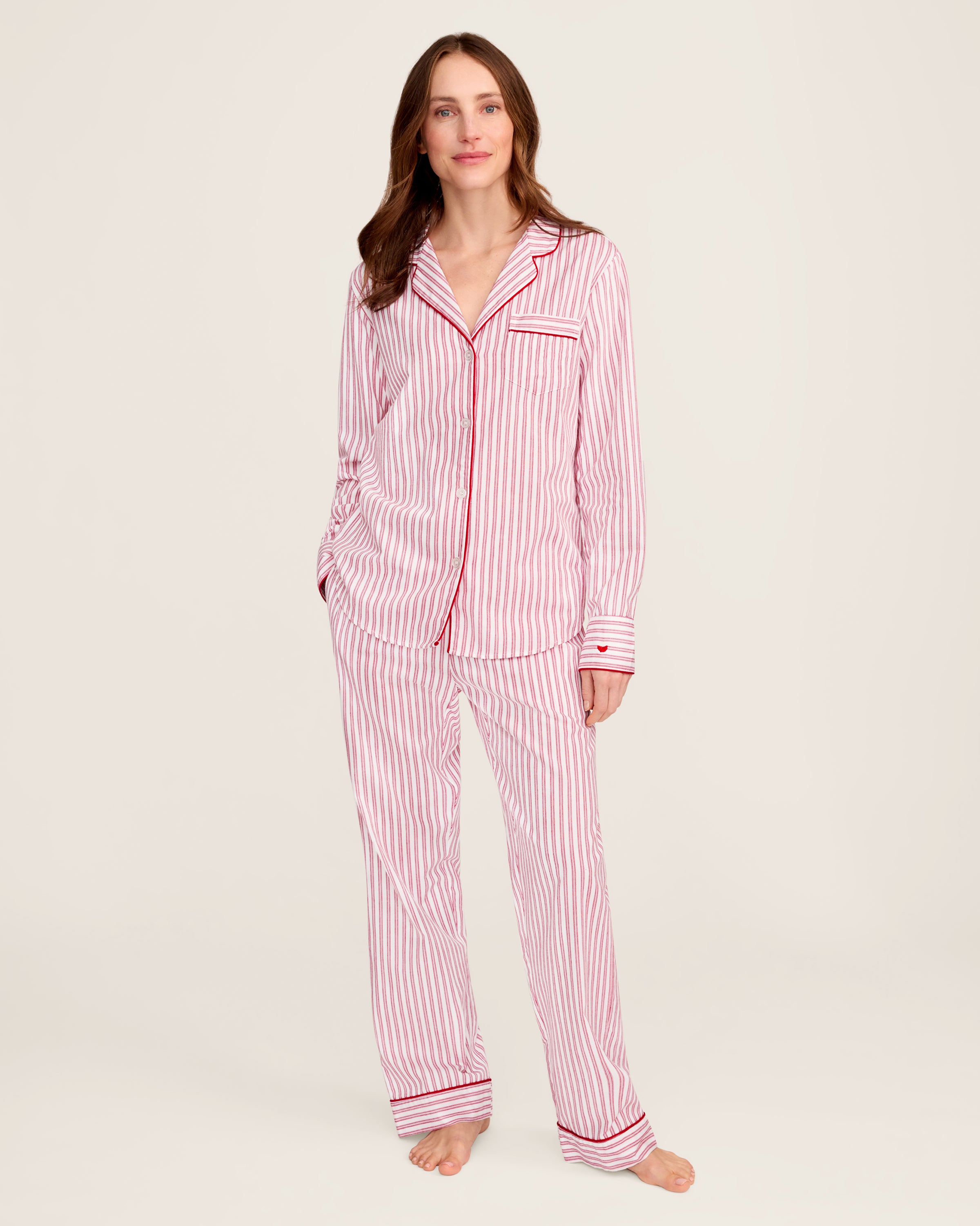The Womens Twill Pajama Set in Antique Red Ticking by Petite Plume features a white shirt with red vertical stripes, front pocket, and button closure. Made from soft, lightweight fabric, the classic pattern offers comfort for sleepwear or casual wear.