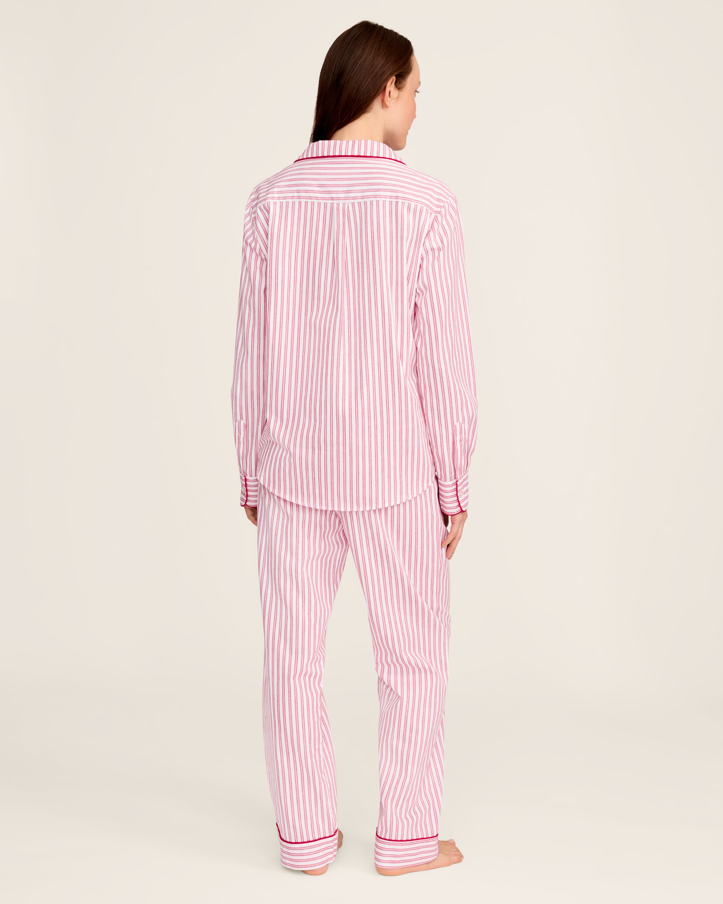 The Womens Twill Pajama Set in Antique Red Ticking by Petite Plume features a white shirt with red vertical stripes, front pocket, and button closure. Made from soft, lightweight fabric, the classic pattern offers comfort for sleepwear or casual wear.