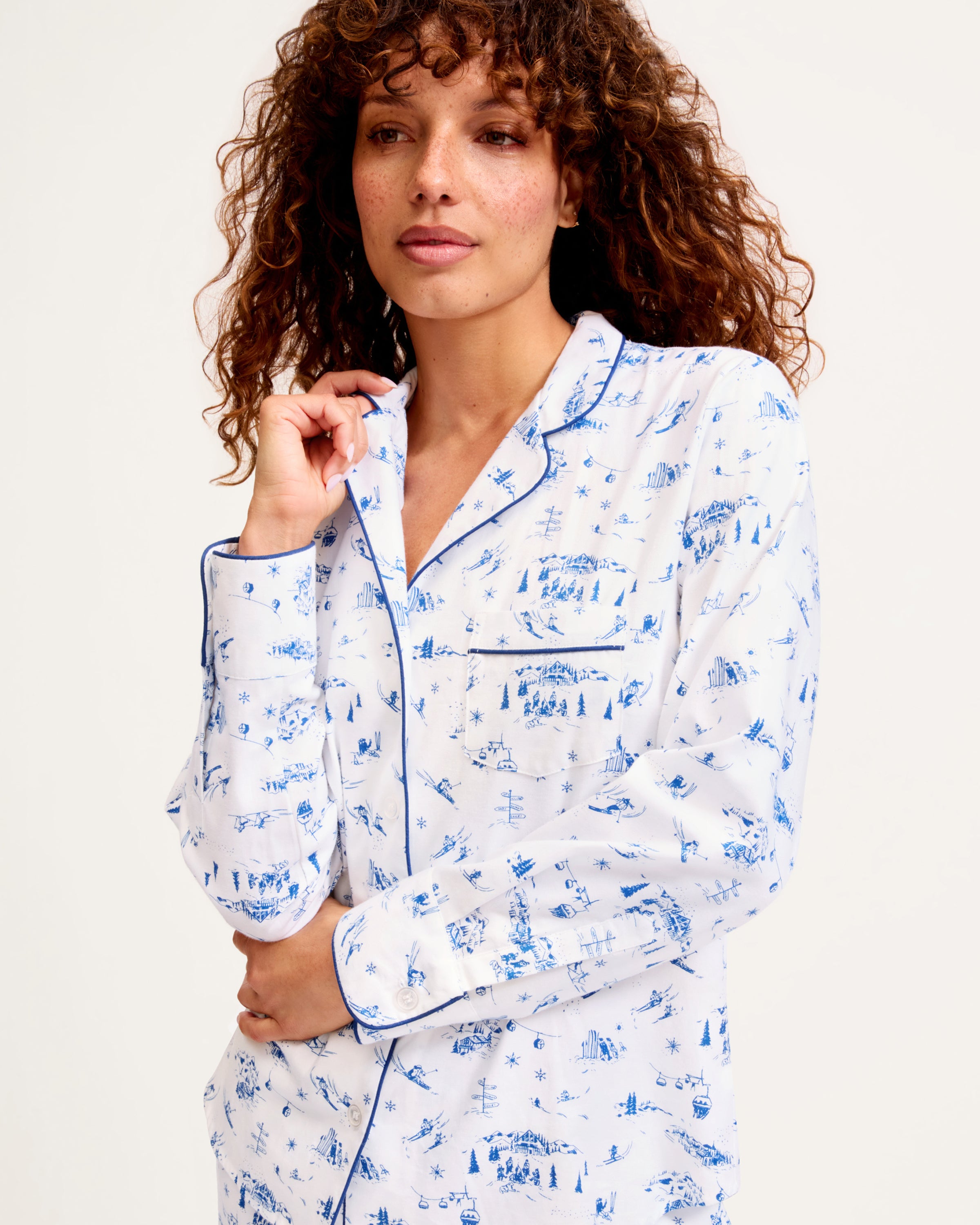 Women's Twill Pajama Set in Chalet Toile, featuring a white long-sleeve button-up shirt and matching pants with blue piping and a blue toile pattern, neatly displayed on a white background.