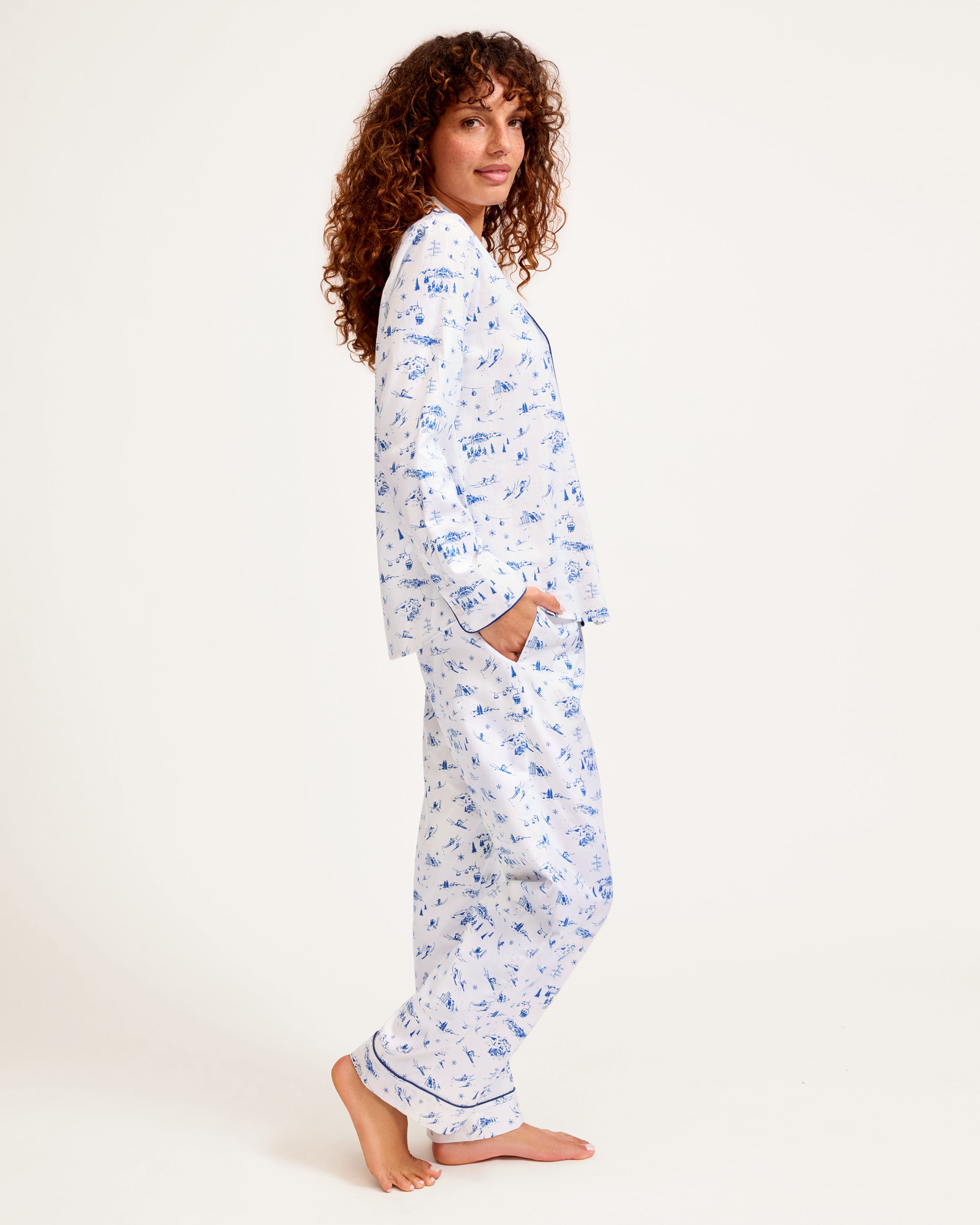 Women's Twill Pajama Set in Chalet Toile, featuring a white long-sleeve button-up shirt and matching pants with blue piping and a blue toile pattern, neatly displayed on a white background.